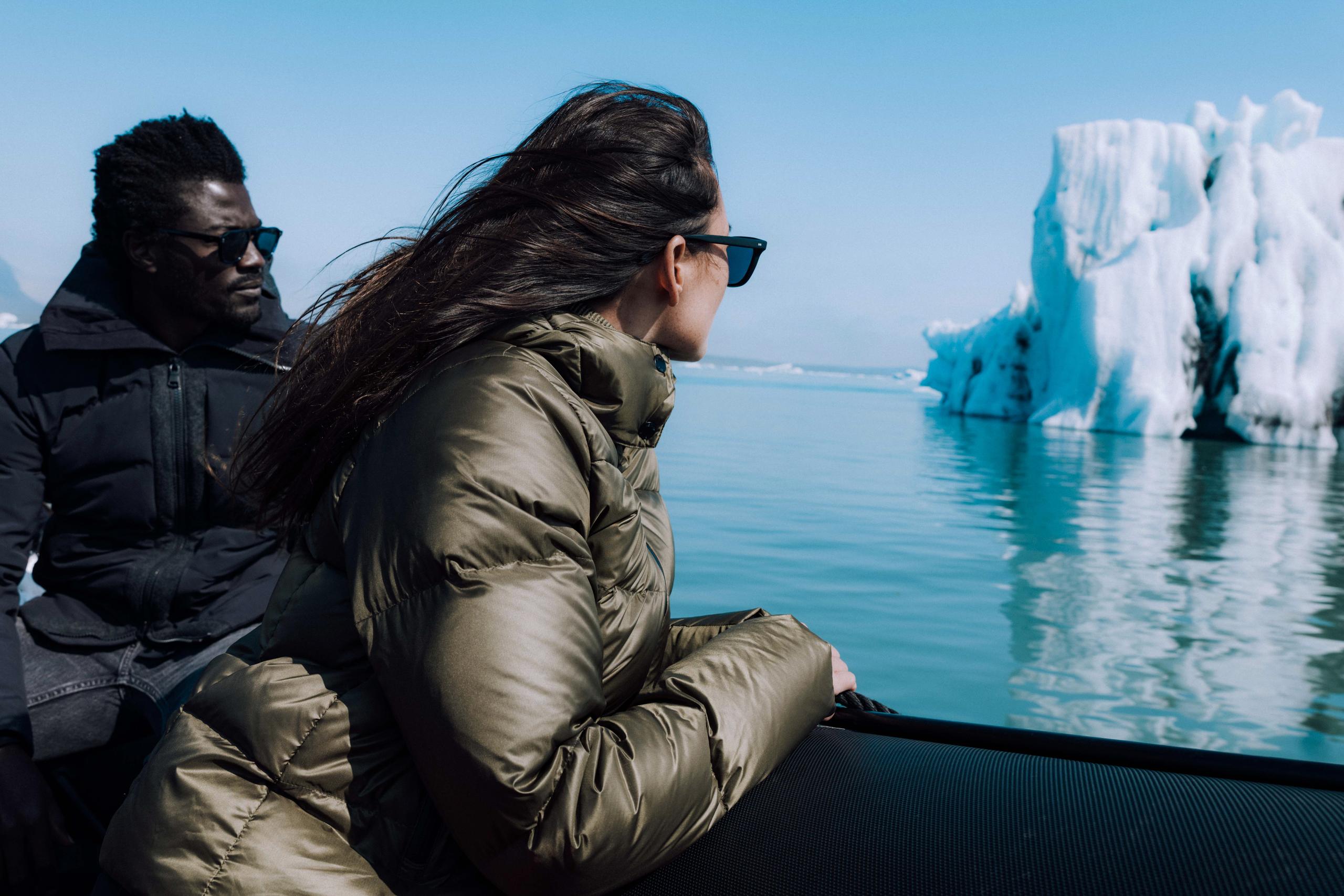 Man and woman in boat looking at glaciers in Iceland