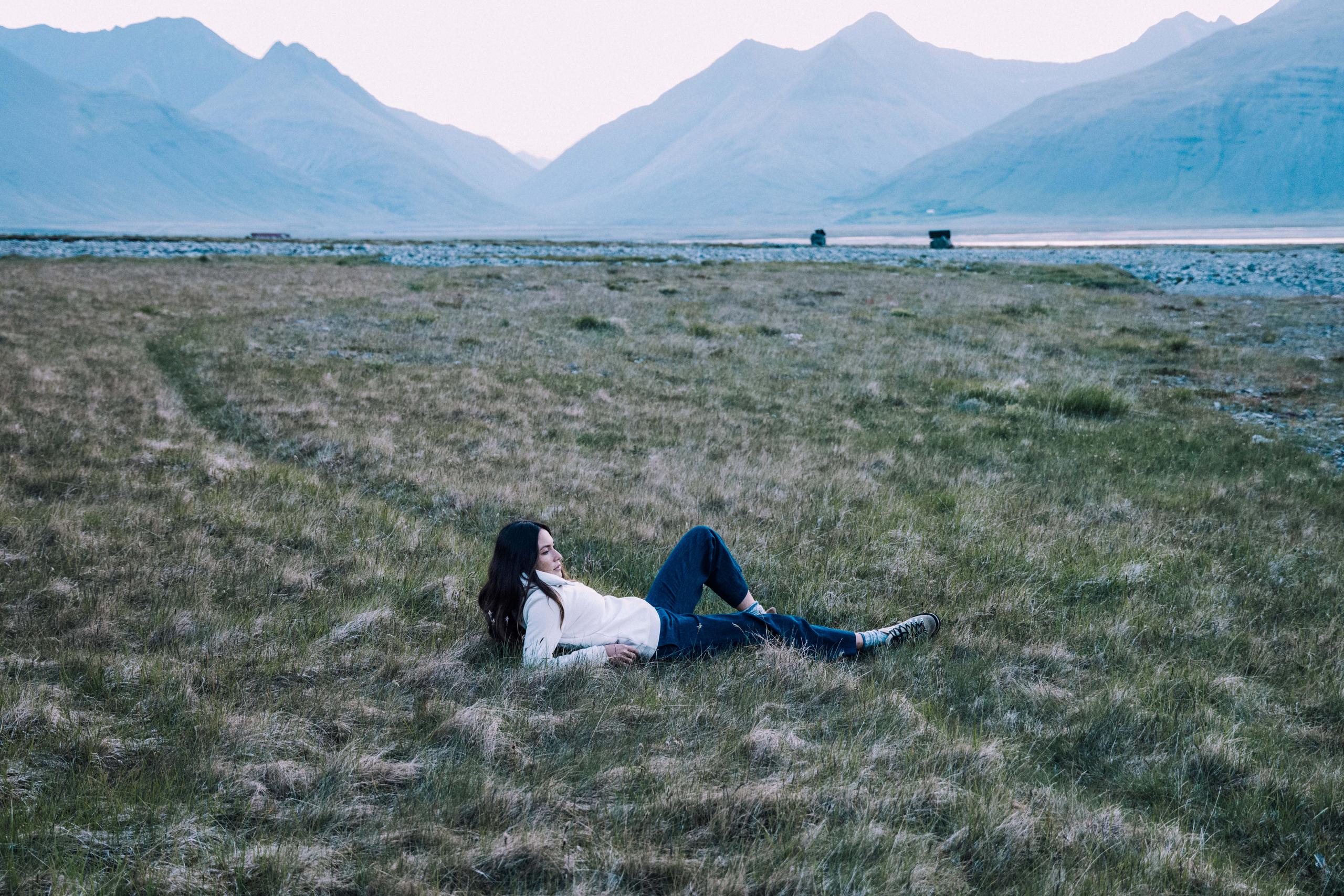 A woman in Align Pullover laying on grass field. 