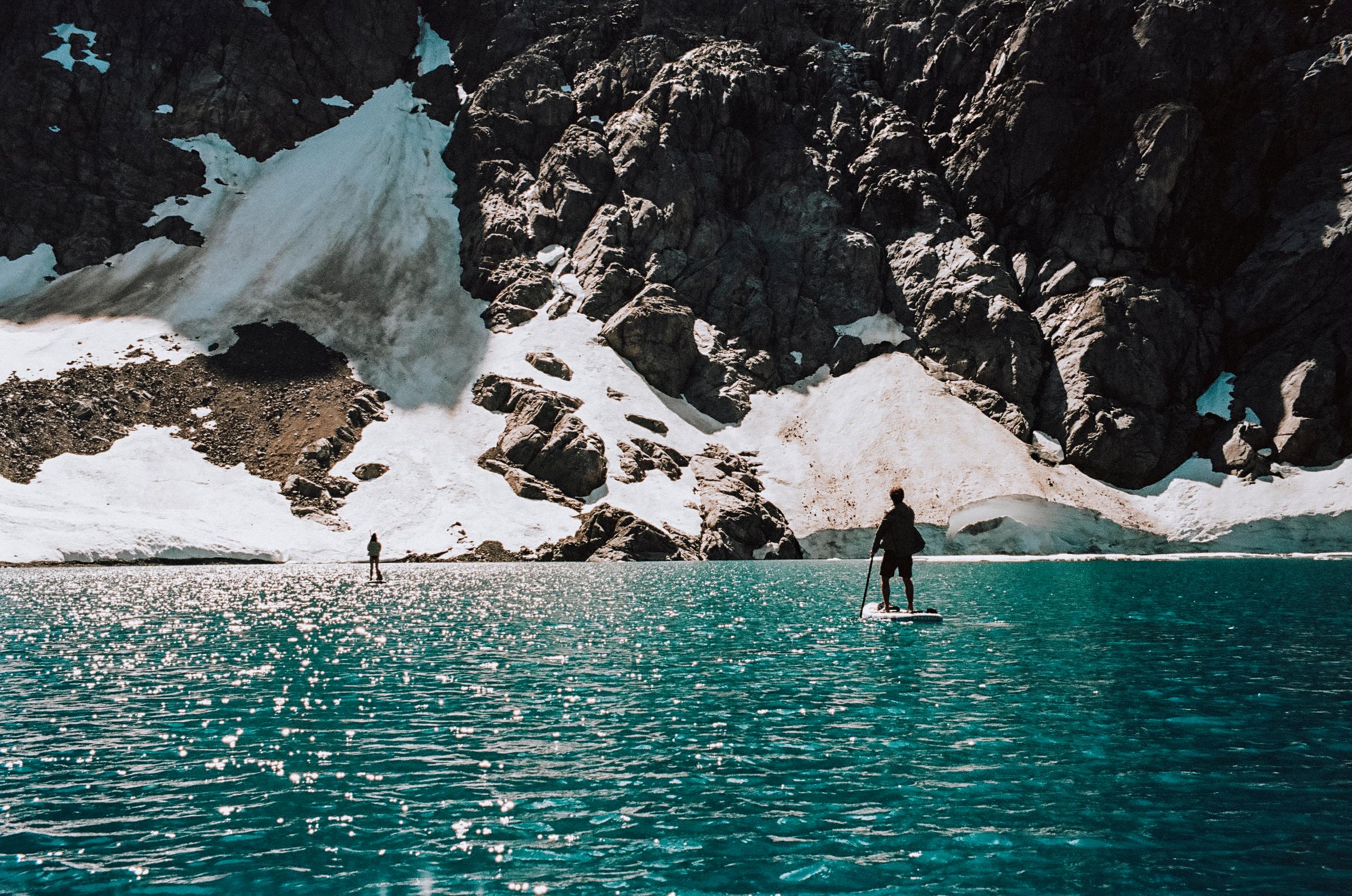  Two people standup paddleboarding on the lake in Patagonia.