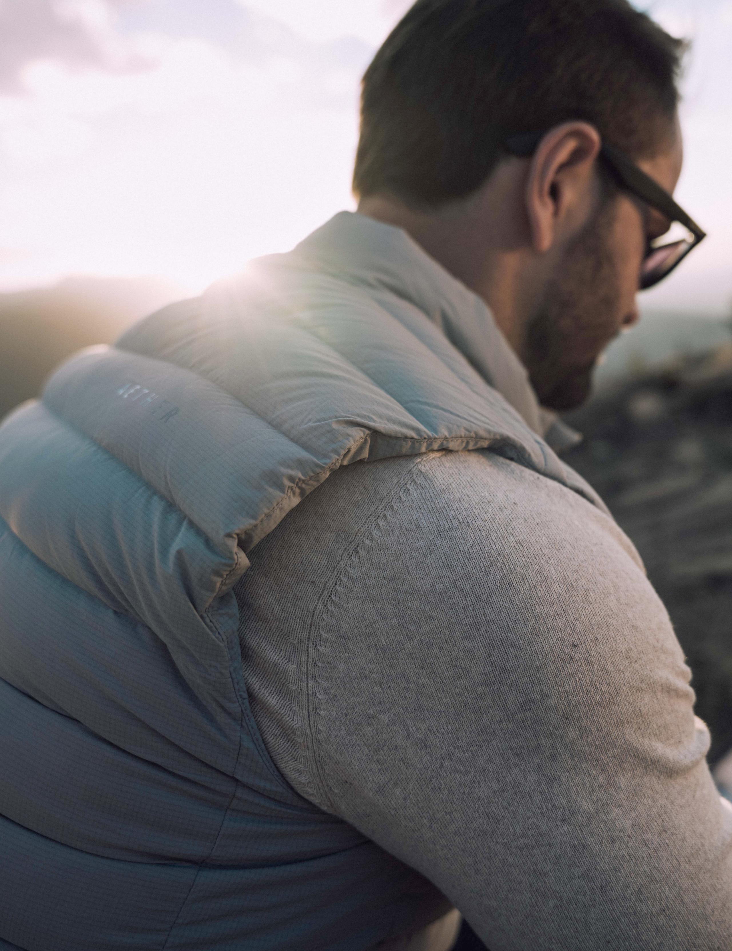 Closeup of man's shoulder wearing the AspenX Launch Vest with the sun setting in Aspen behind him
