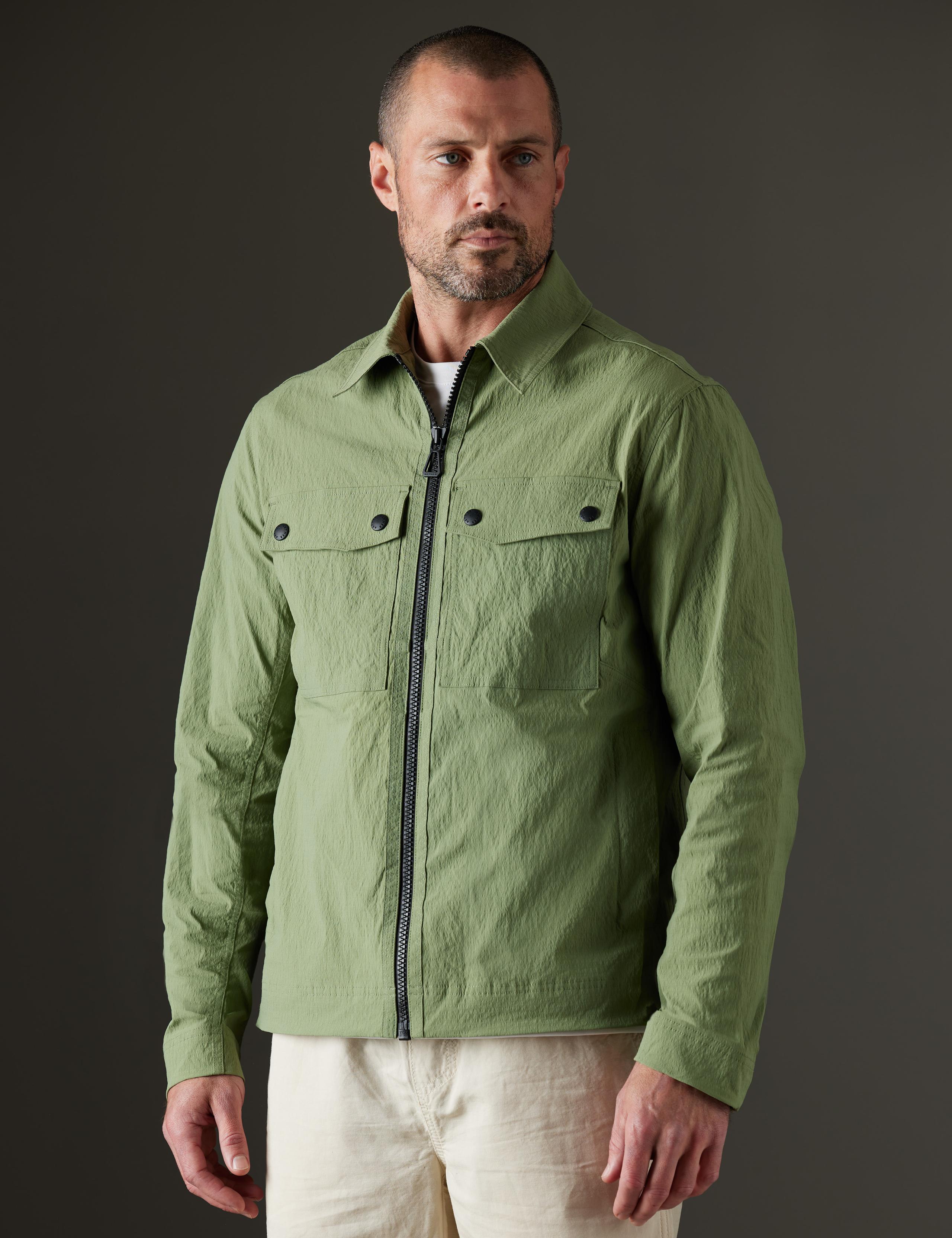 Man in studio wearing the Baxter Jacket in Mineral Green