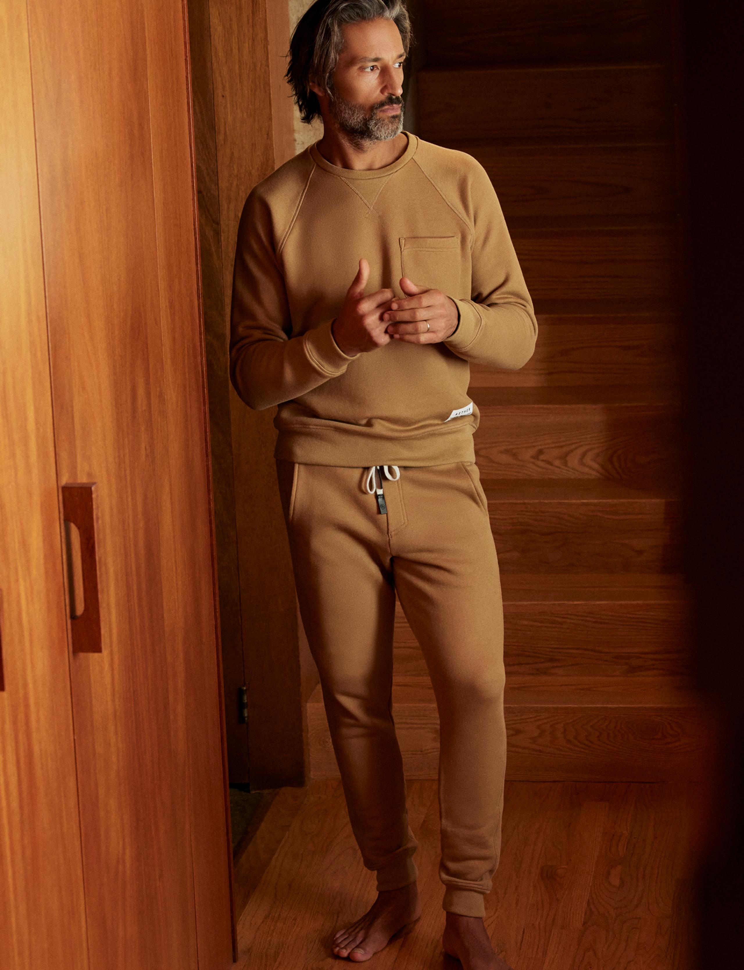 Man wearing Foundation Pocket Crew and Sweatpant standing inside mid-century home