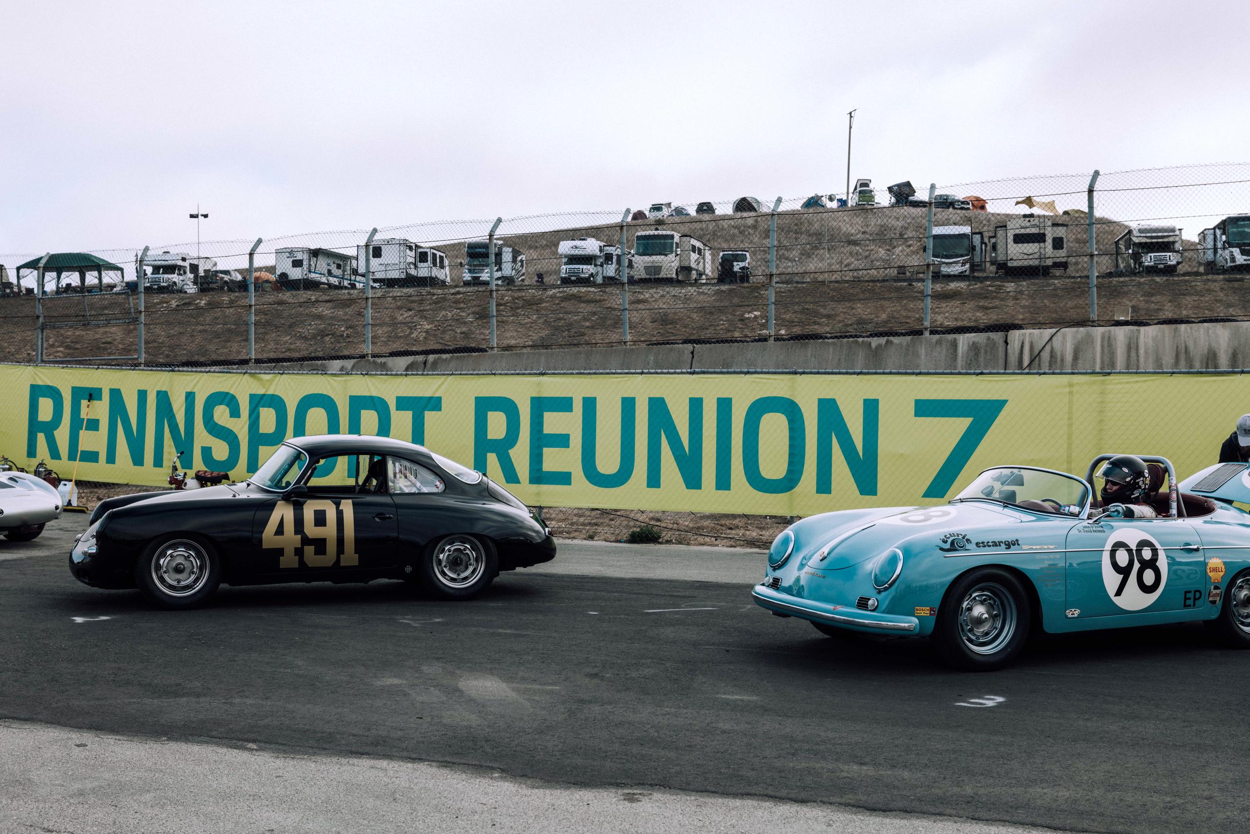 Two vintage Porsche's in front of Rennsport Reunion 7 banner