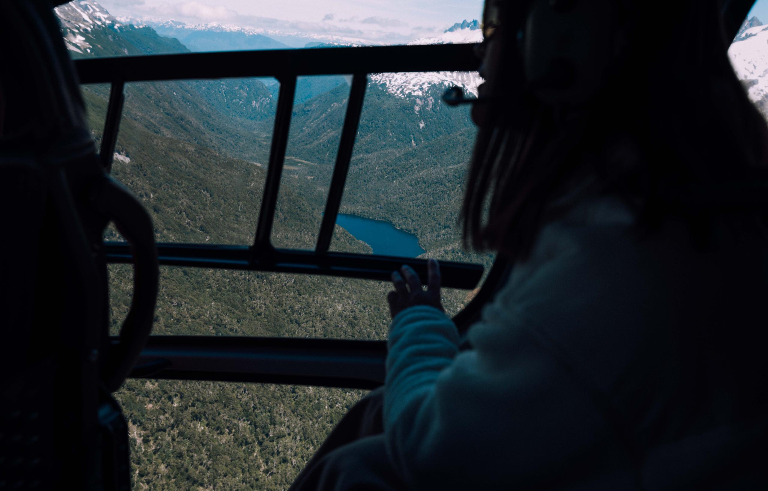 Woman in helicopter overlooking terrain in Patagonia