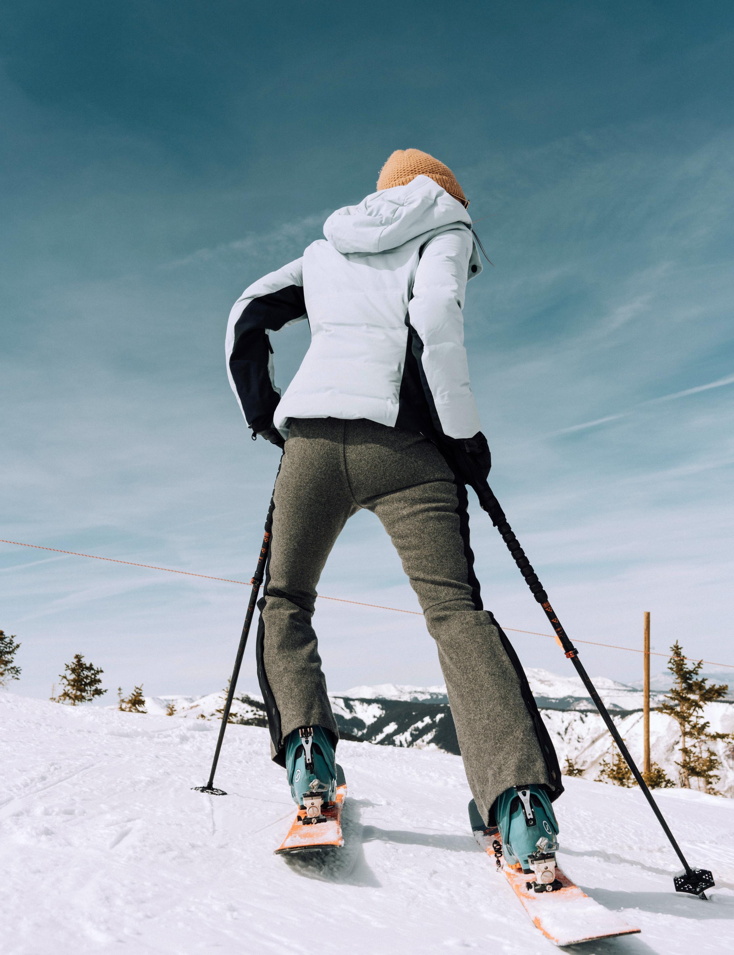 Woman wearing Victory Wool Snow Pants pausing to look at the view while skiing