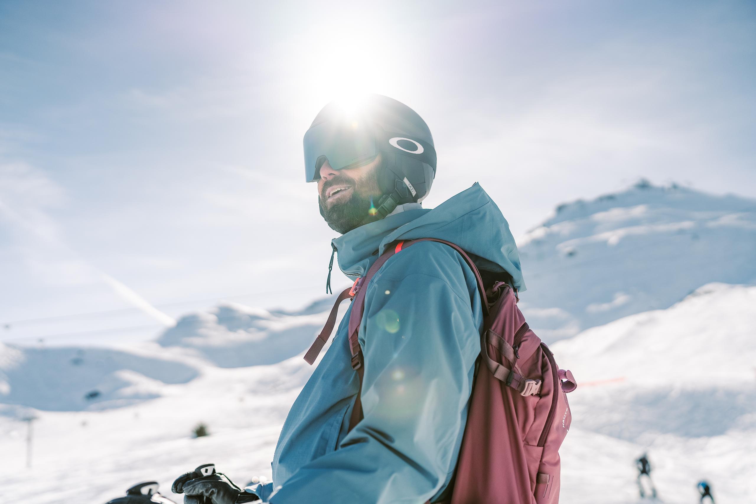 Skier on mountain in Courchevel with the sun shining behind him