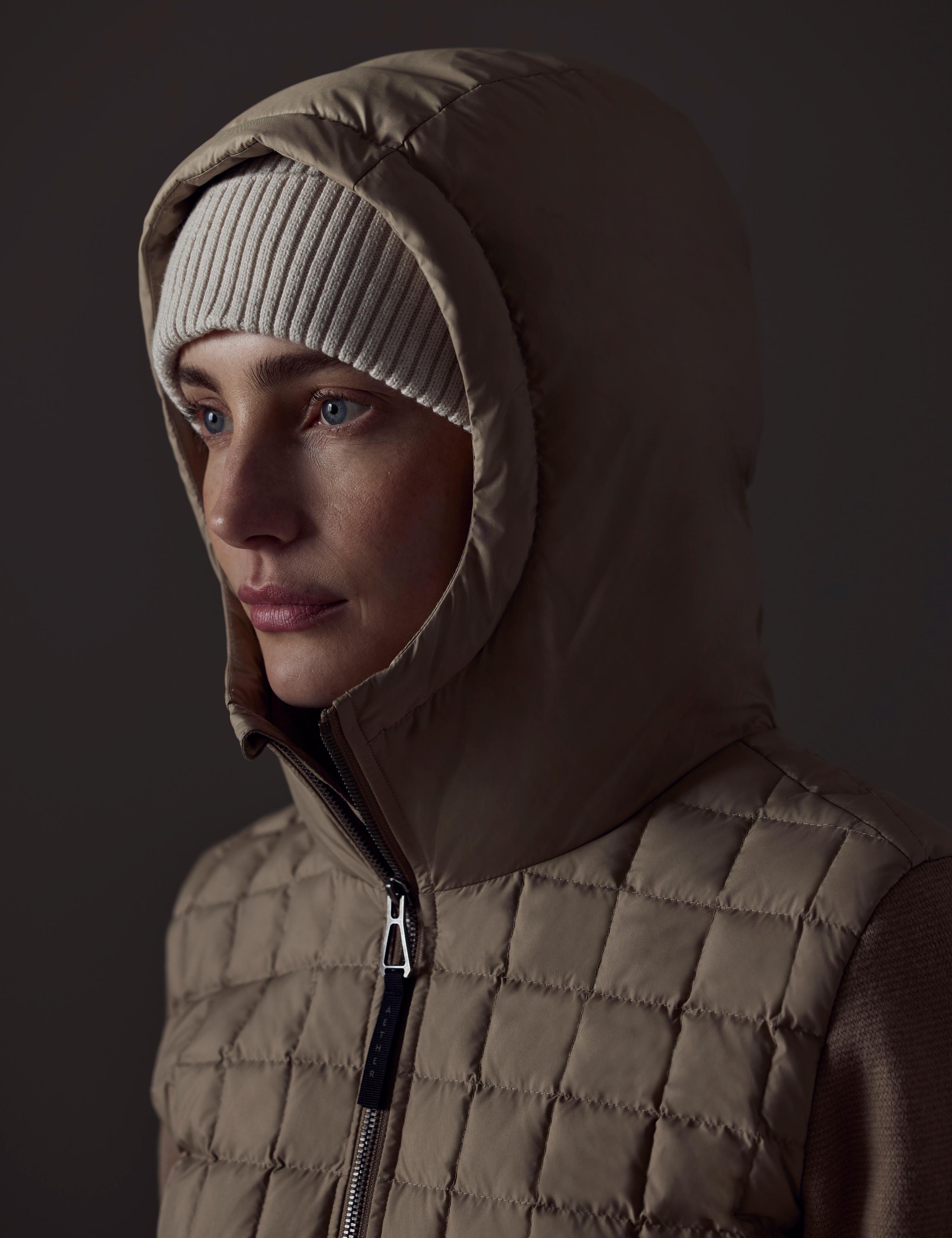 Woman wearing the Phase Hooded Sweater with the hood up.