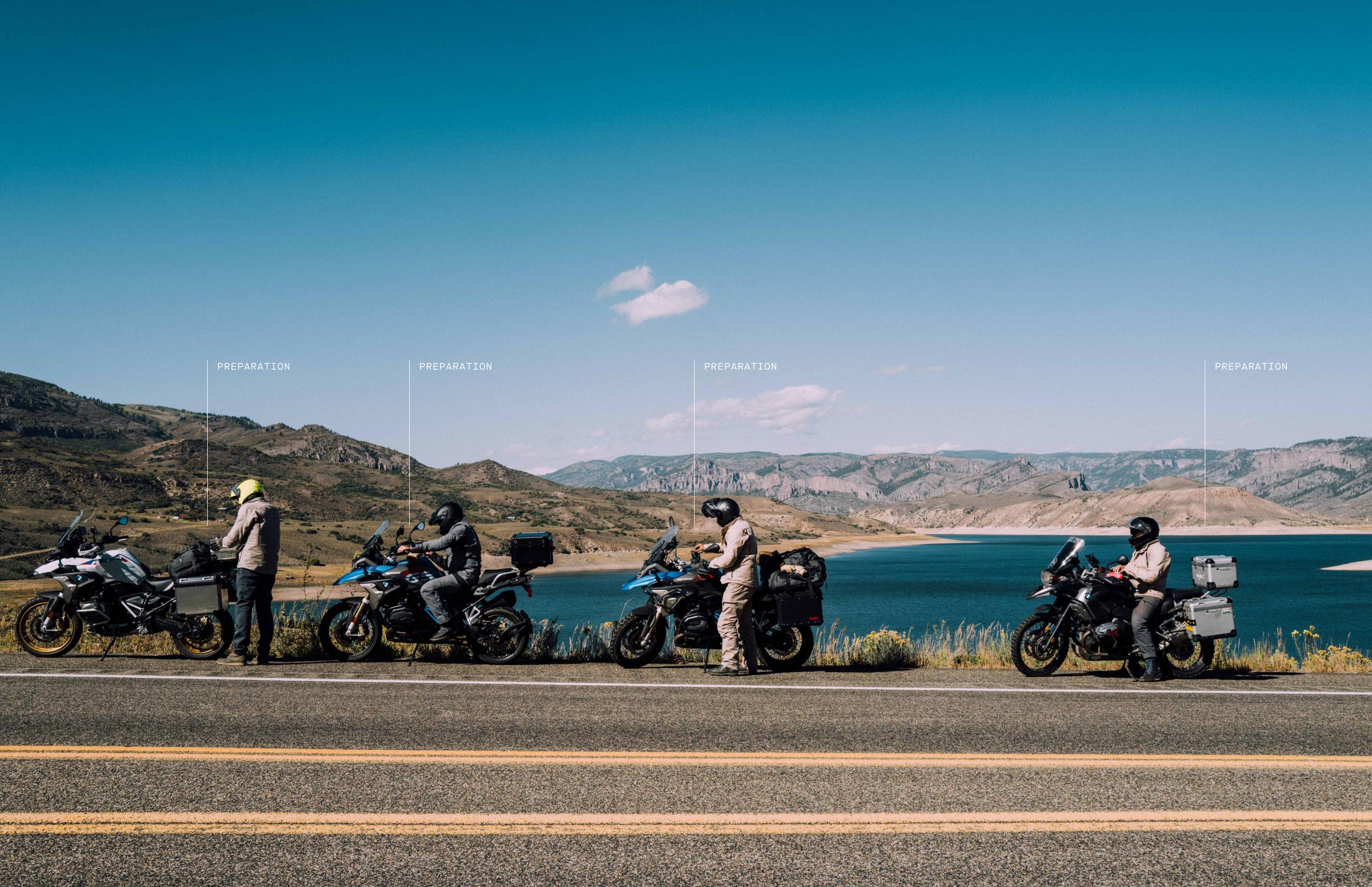 Four motorcyclists along roadside in front of Colorado landscape with lake