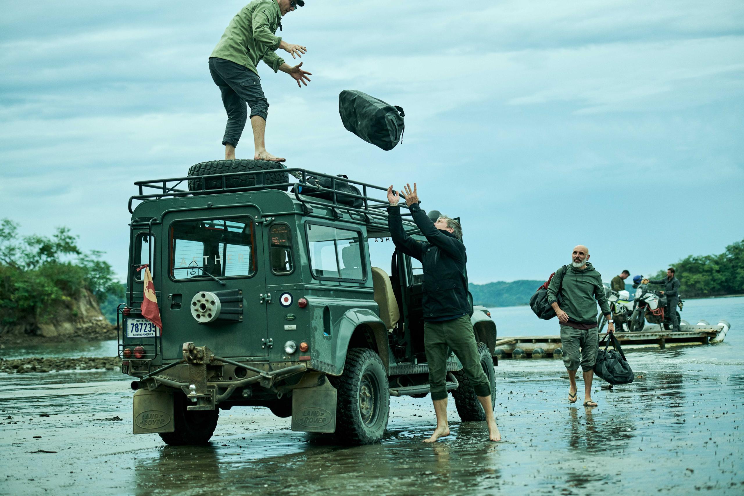 People unloading gear from a Jeep.