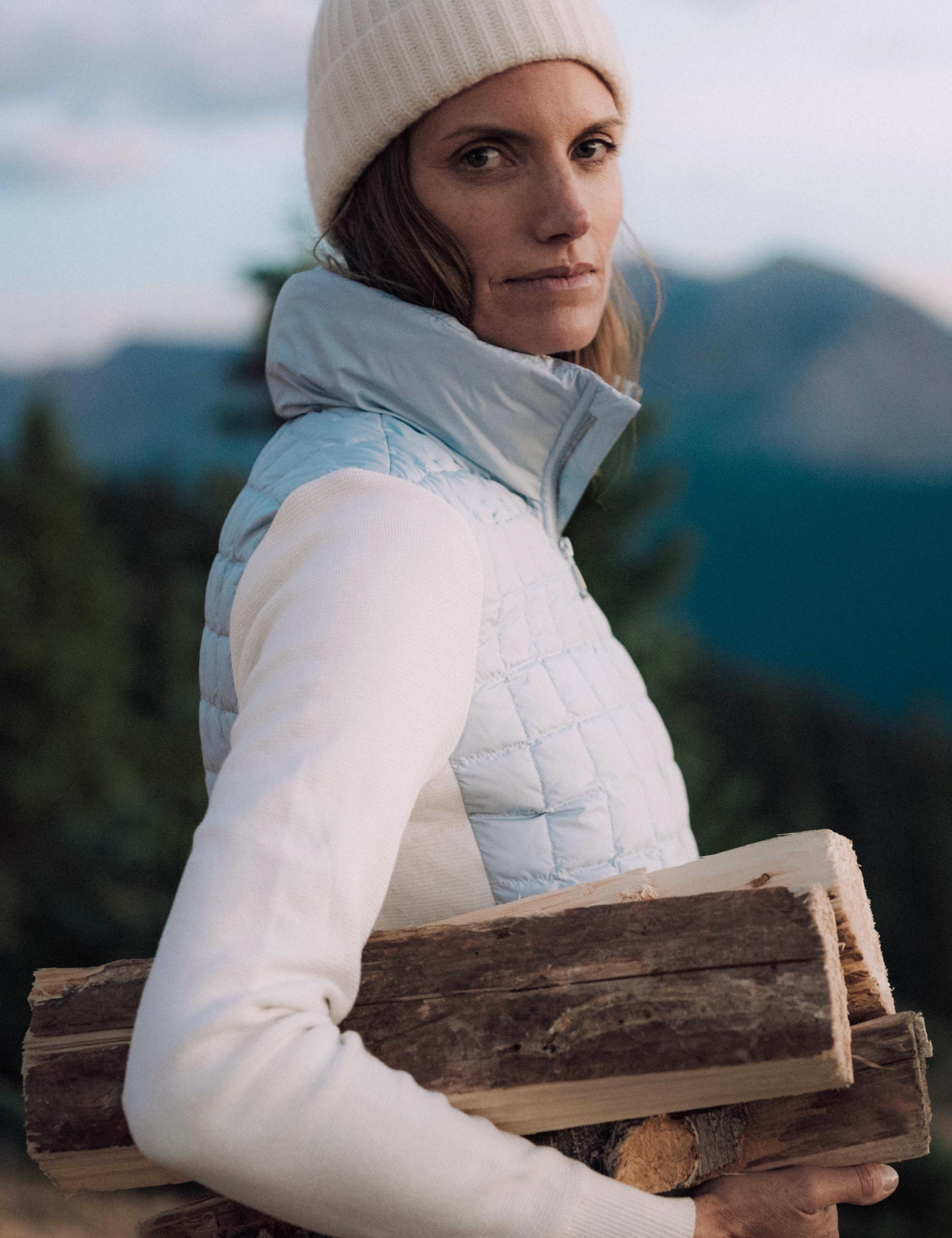 Woman holding chopped wood with Aspen mountains in background