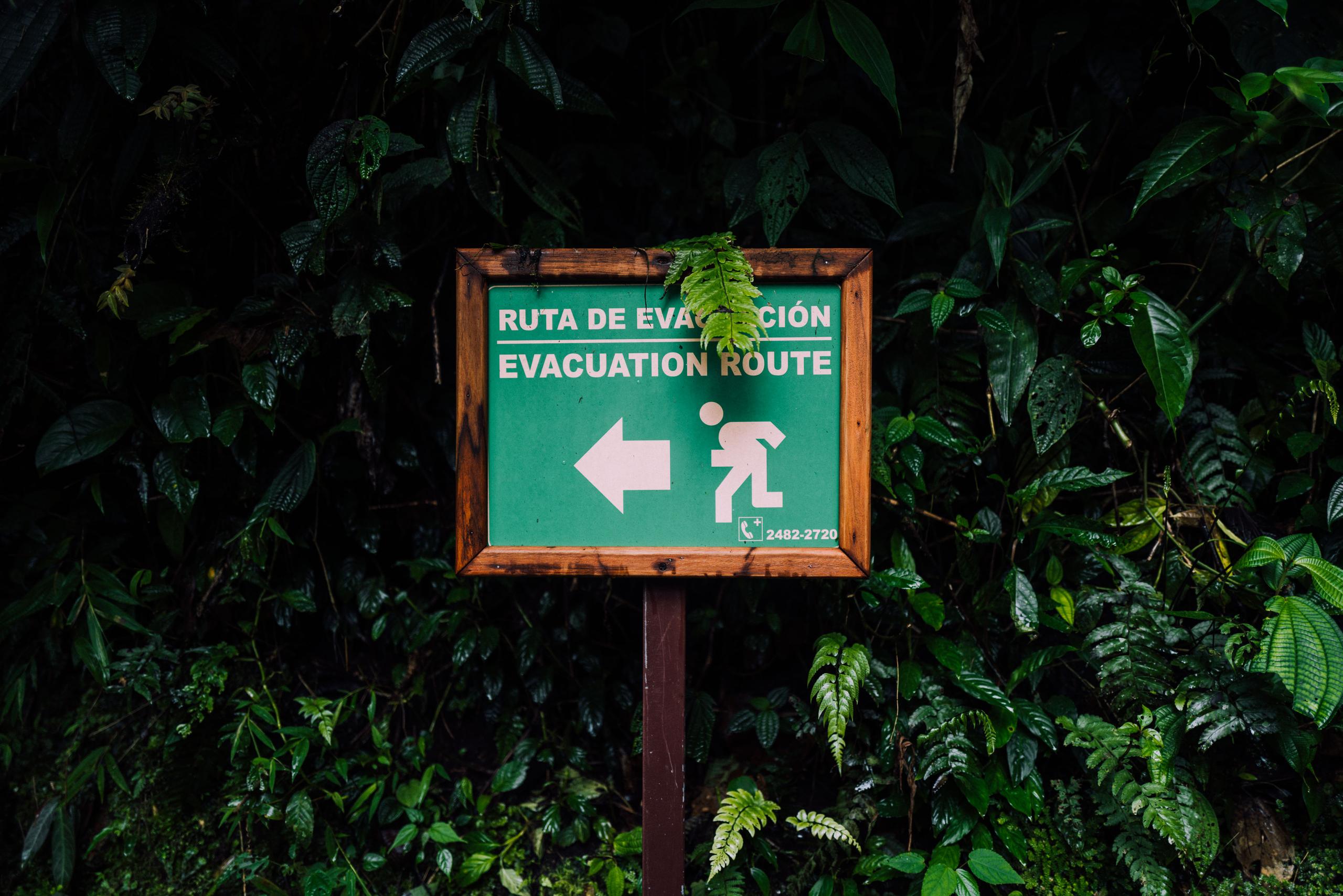 Evacuation route sign in Costa Rica against green jungle background