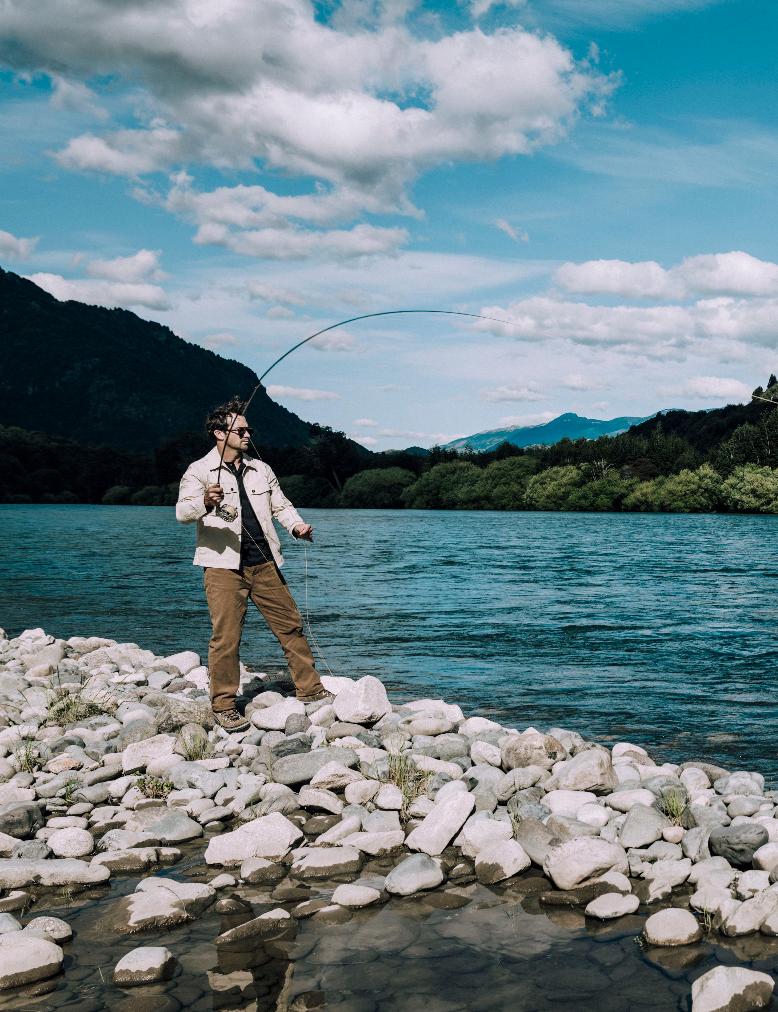 Man on rivers edge fishing in the Patagonia region of Chile