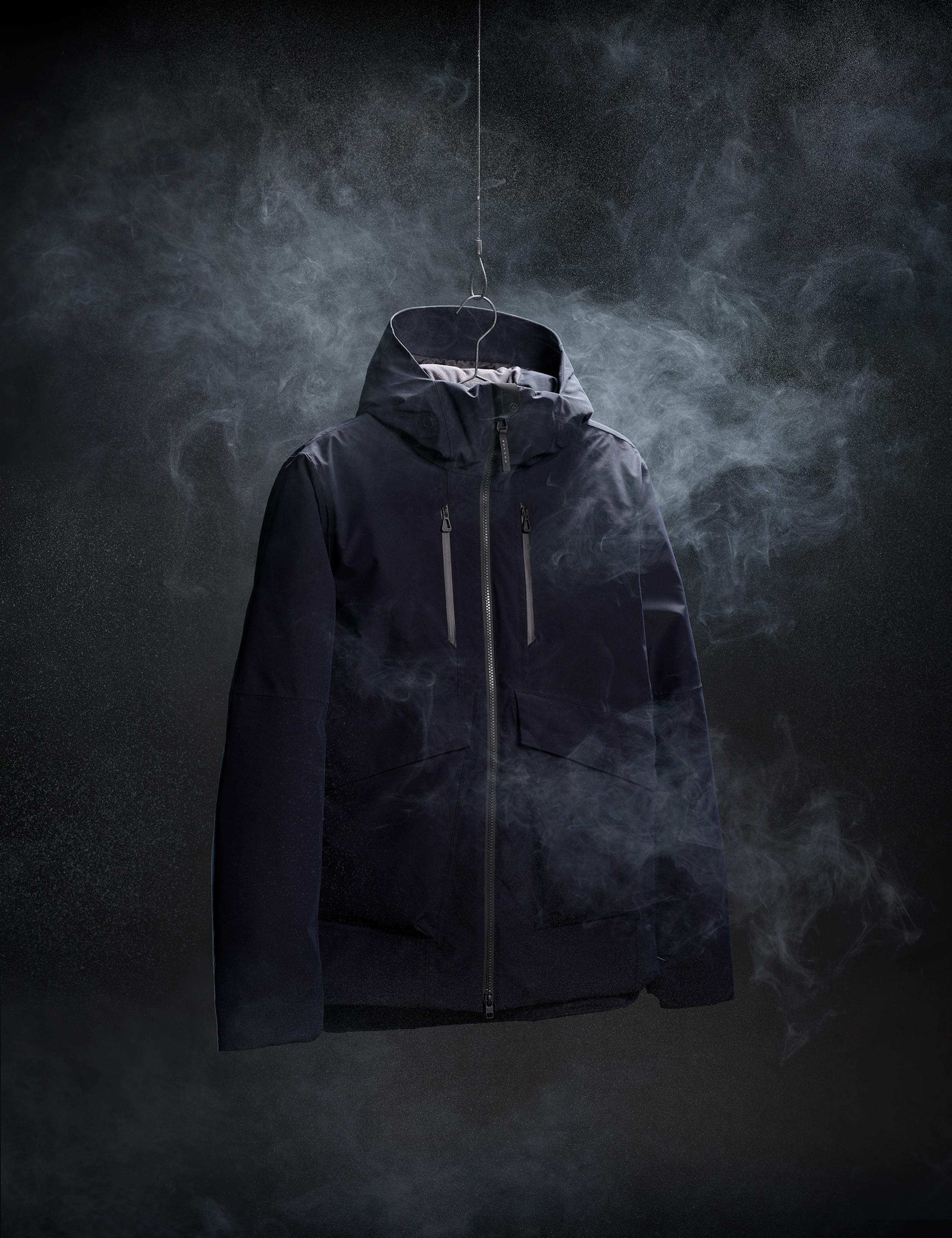 In studio photo of Silverton Jacket hanging against black background with white mist around it
