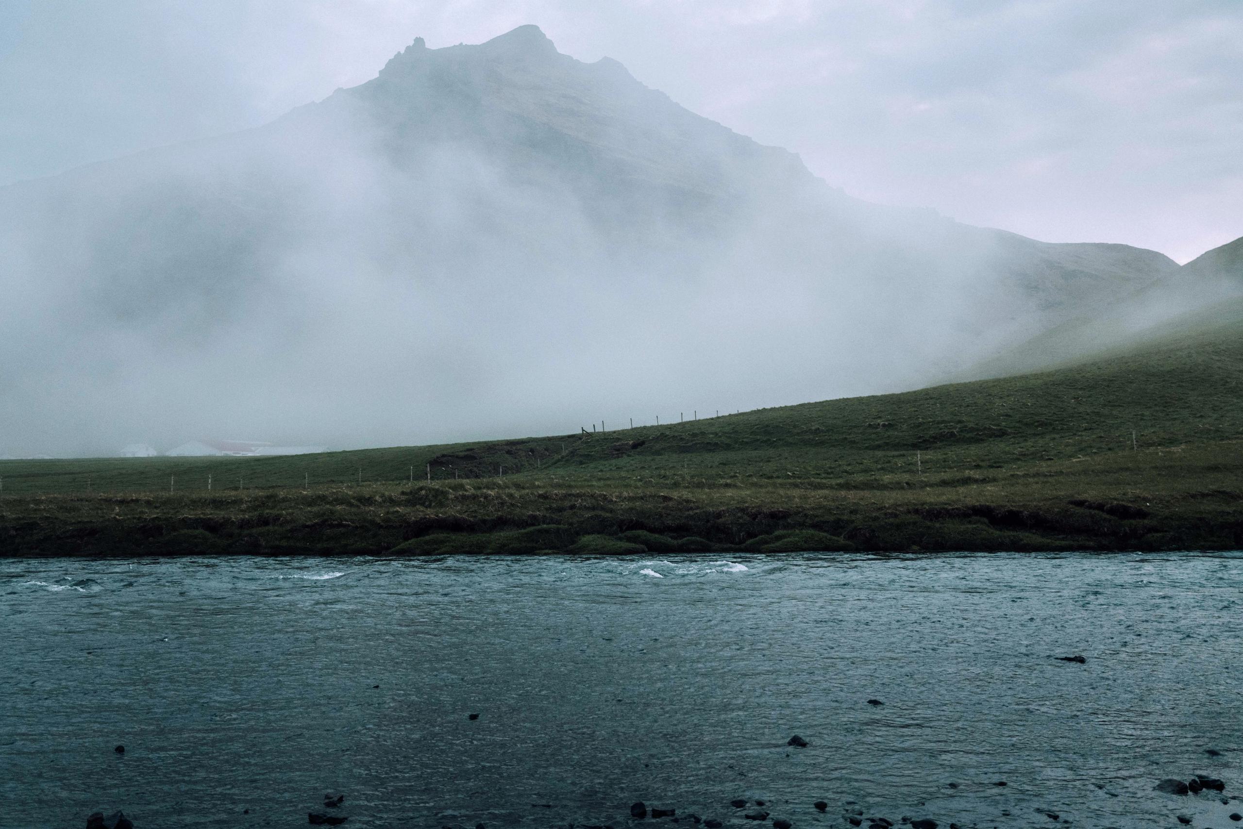 Misty landscape in Iceland next to mountains and river