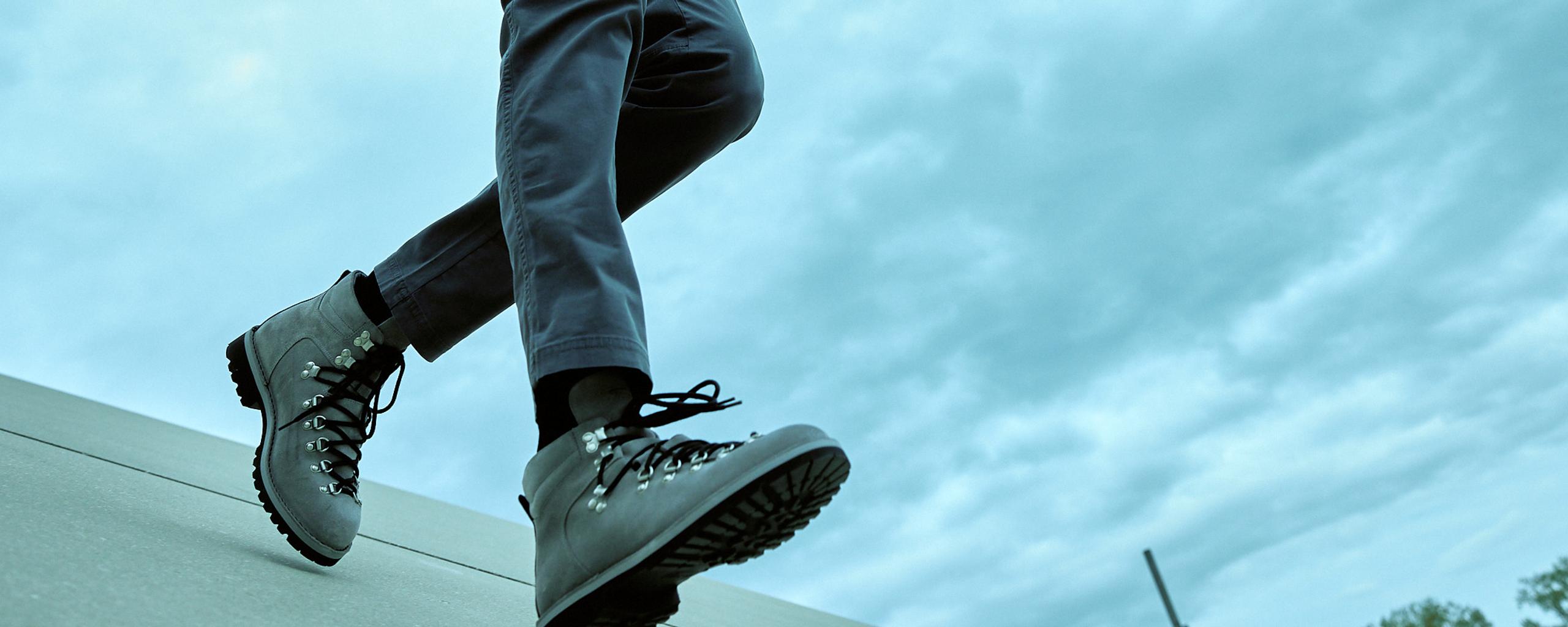 Closeup of man's boots while walking down concrete architecture