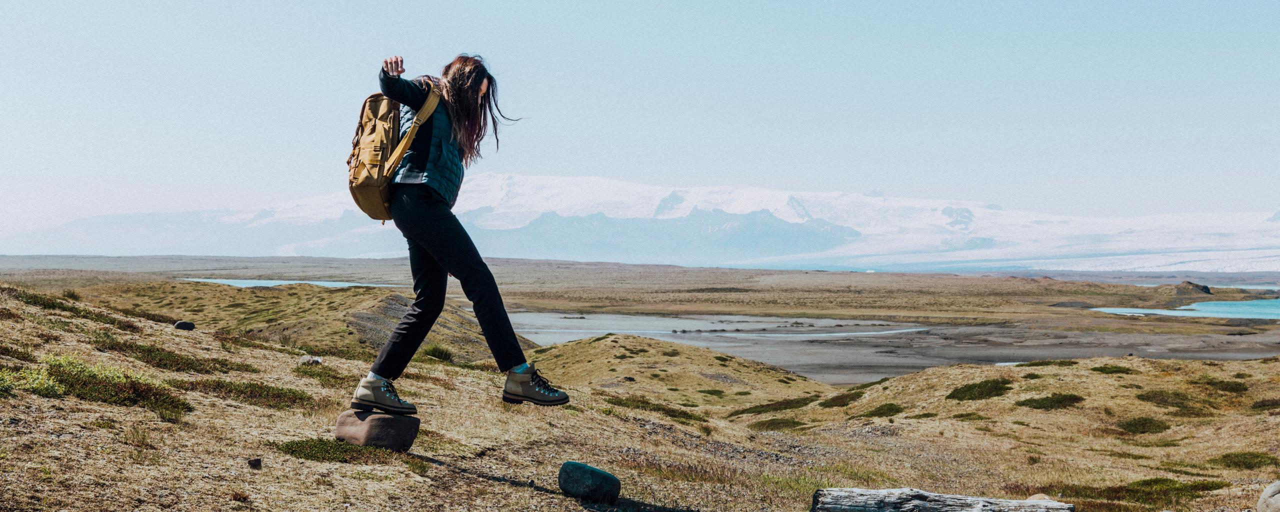 Woman walking on grassy landscape in Iceland