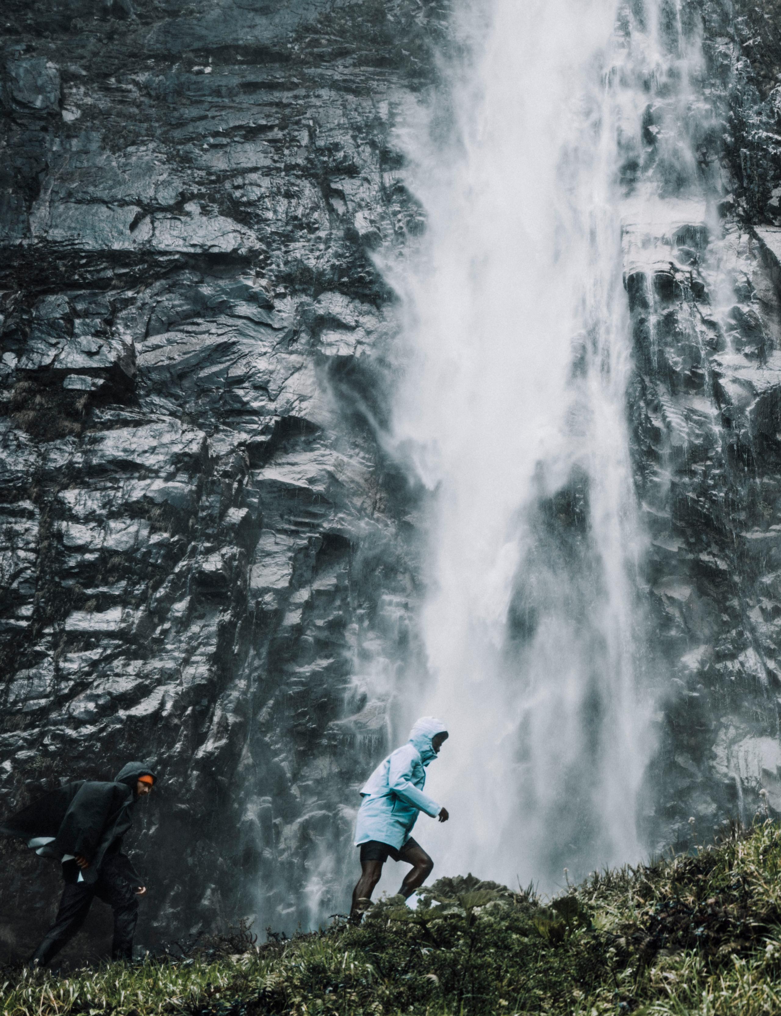Man walking alongside waterfall in Patagonia region of Chile