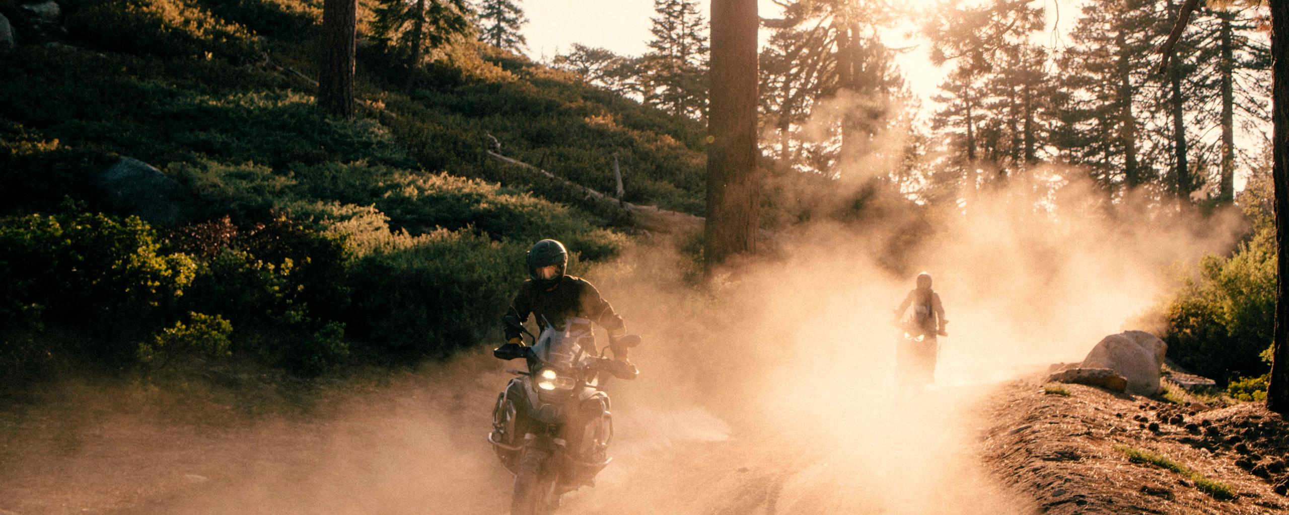 Two motorcyclists riding on dirt path through mountains in Big Bear, California