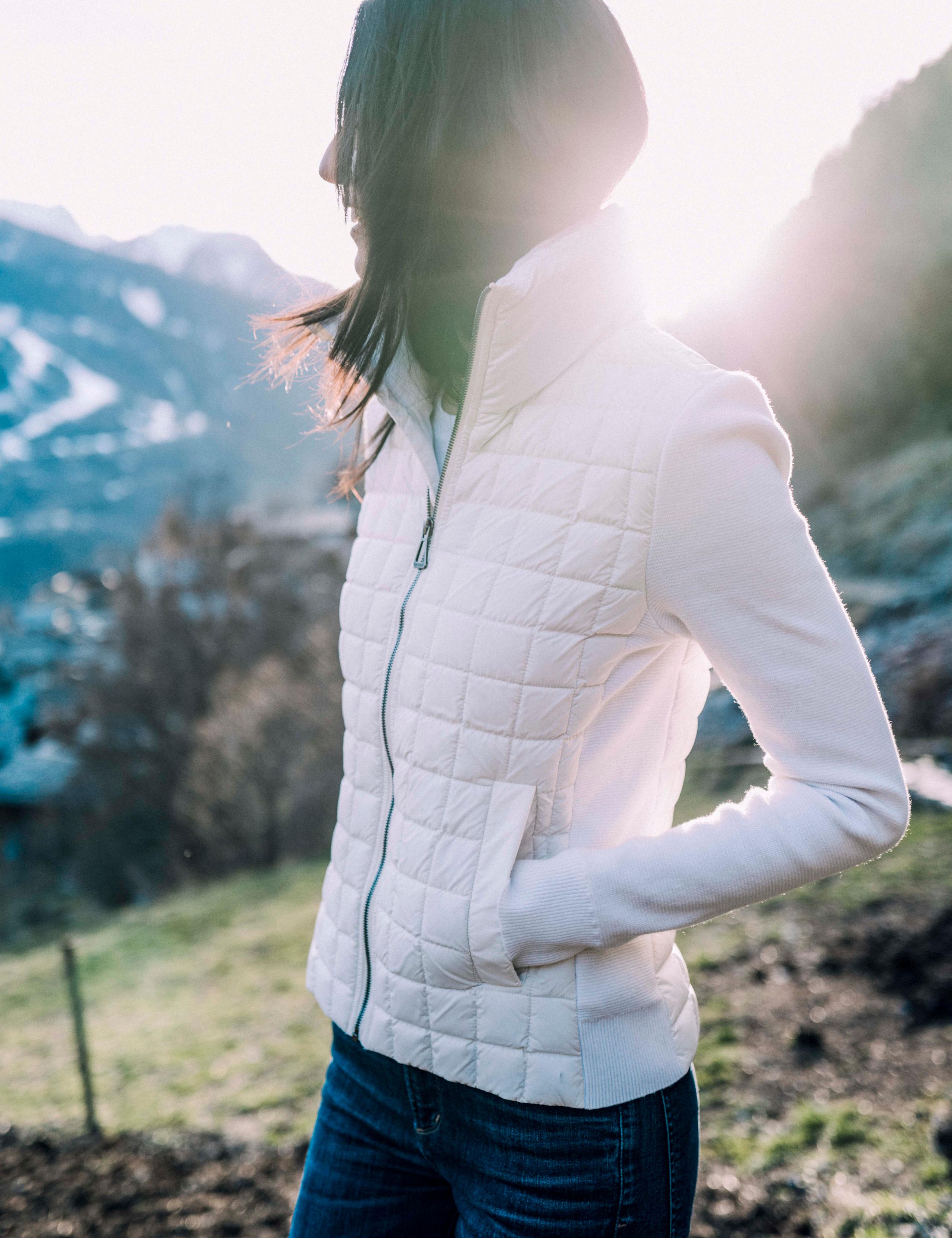 Woman wearing Phase Full-Zip looking over countryside in Lyon, France with snowy mountains at sunset