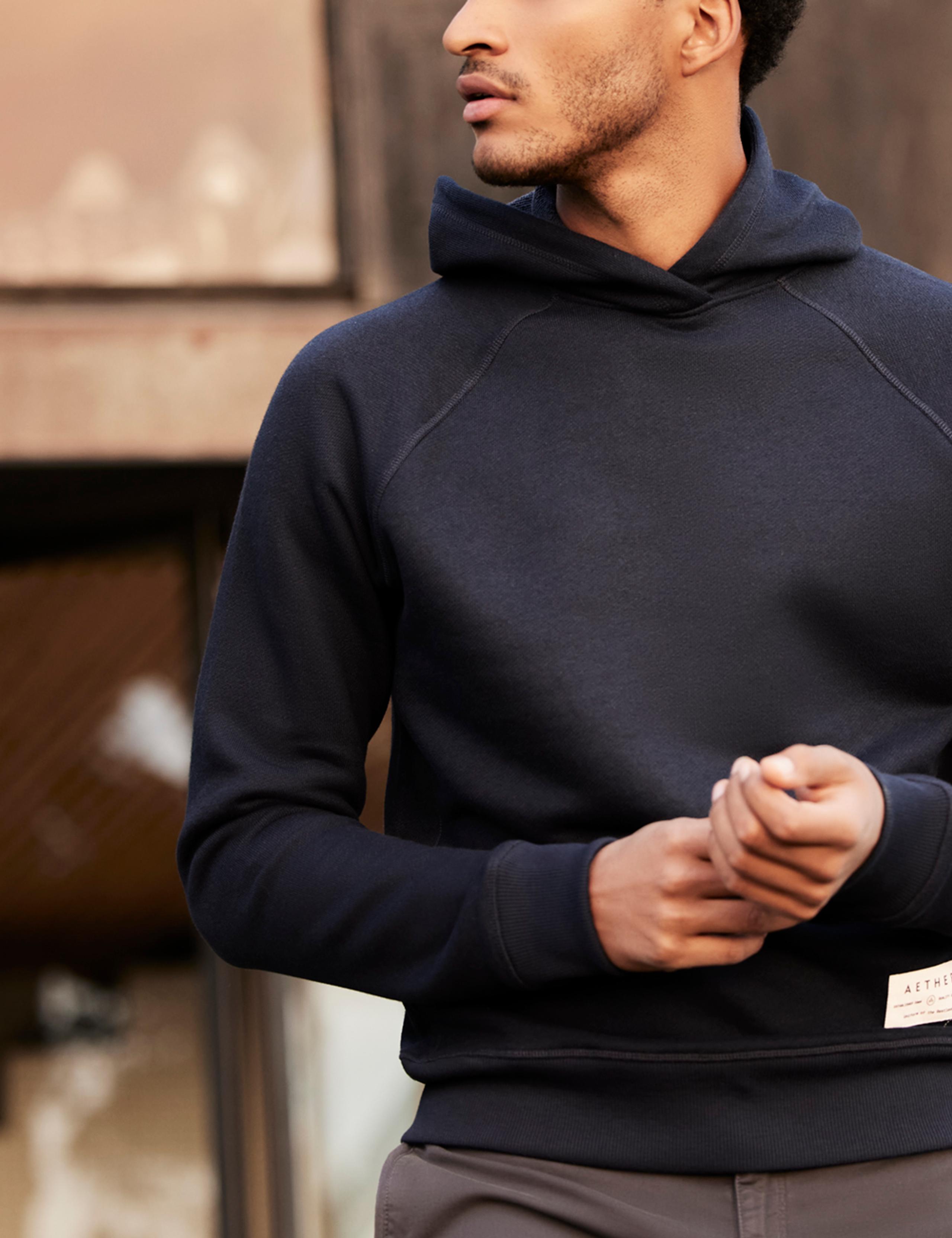 Man wearing Foundation Hoodie outside mid-century home
