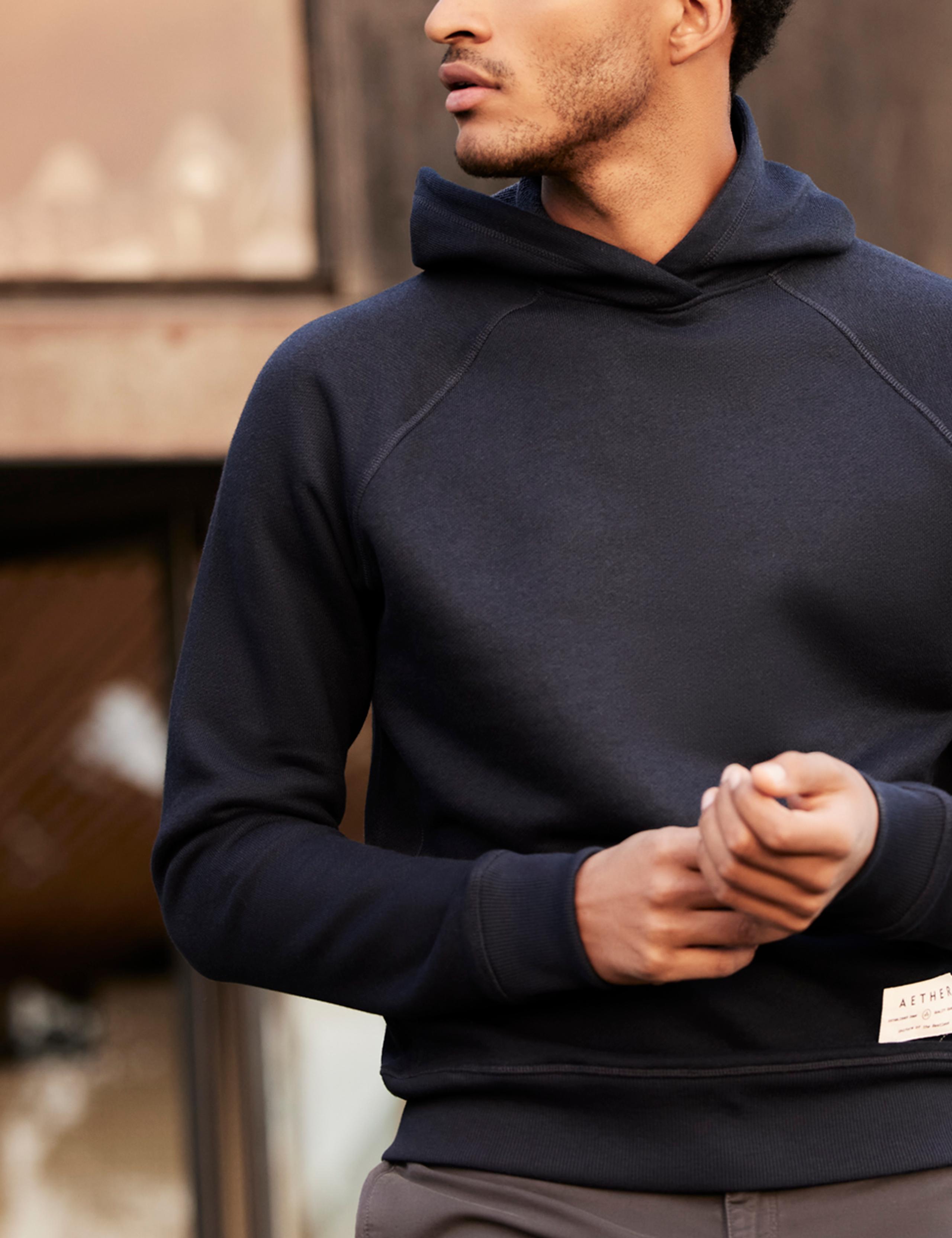 Man wearing Foundation Hoodie outside of mid-century home