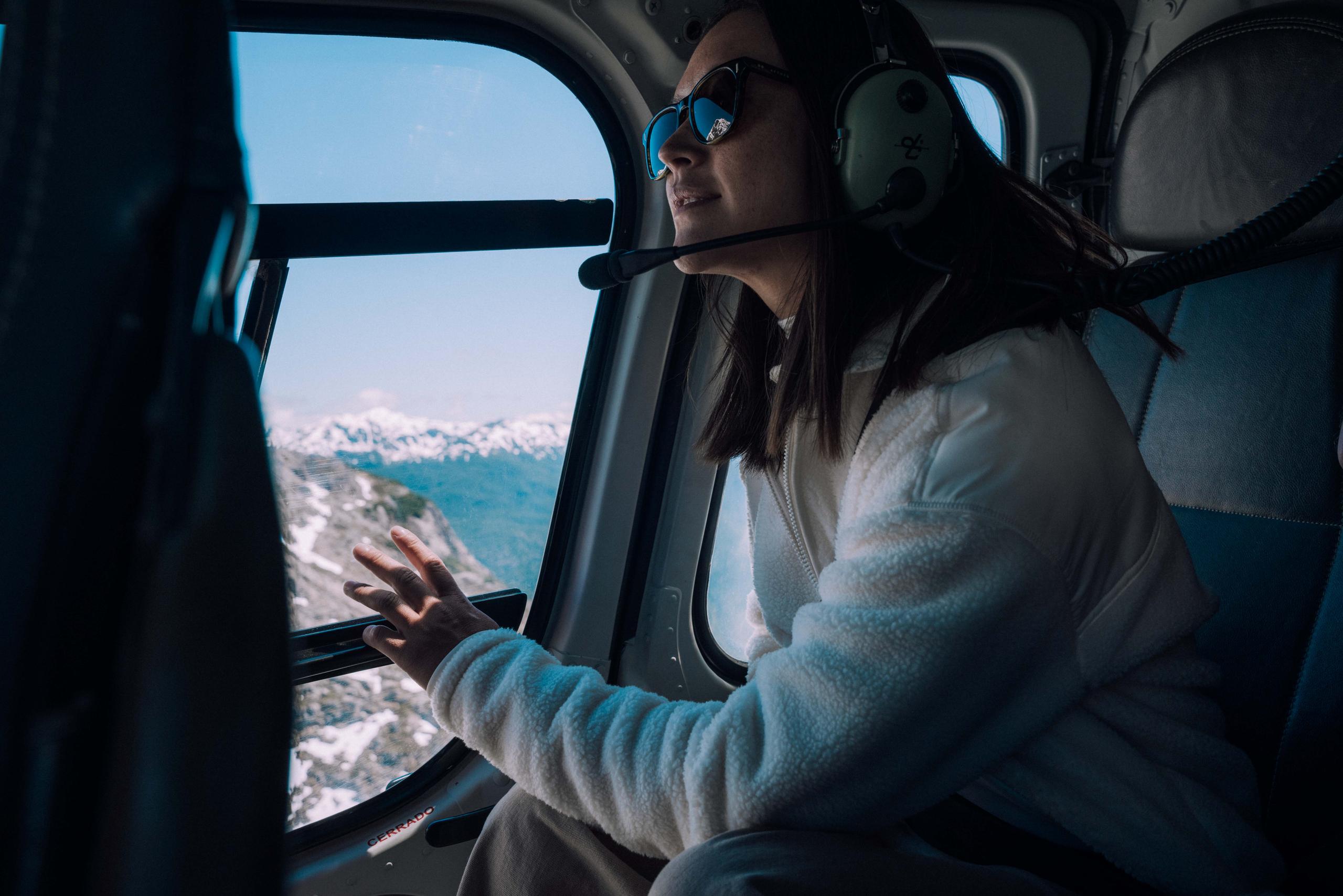 Woman in Terrain Fleece Anorak in helicopter looking out the window overlooking Patagonia, Chile