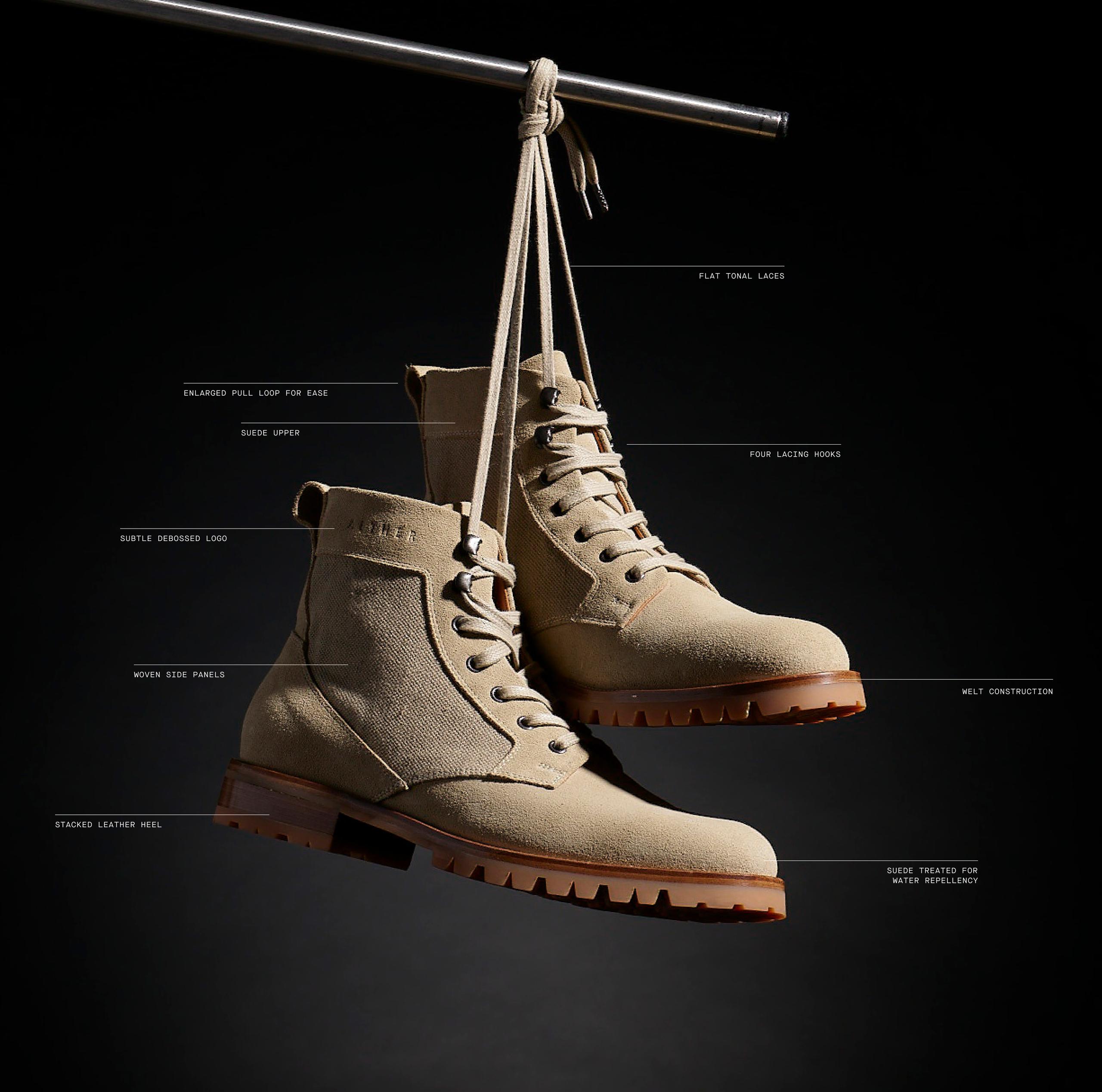 Ojai Boots hanging from laces in studio against black background
