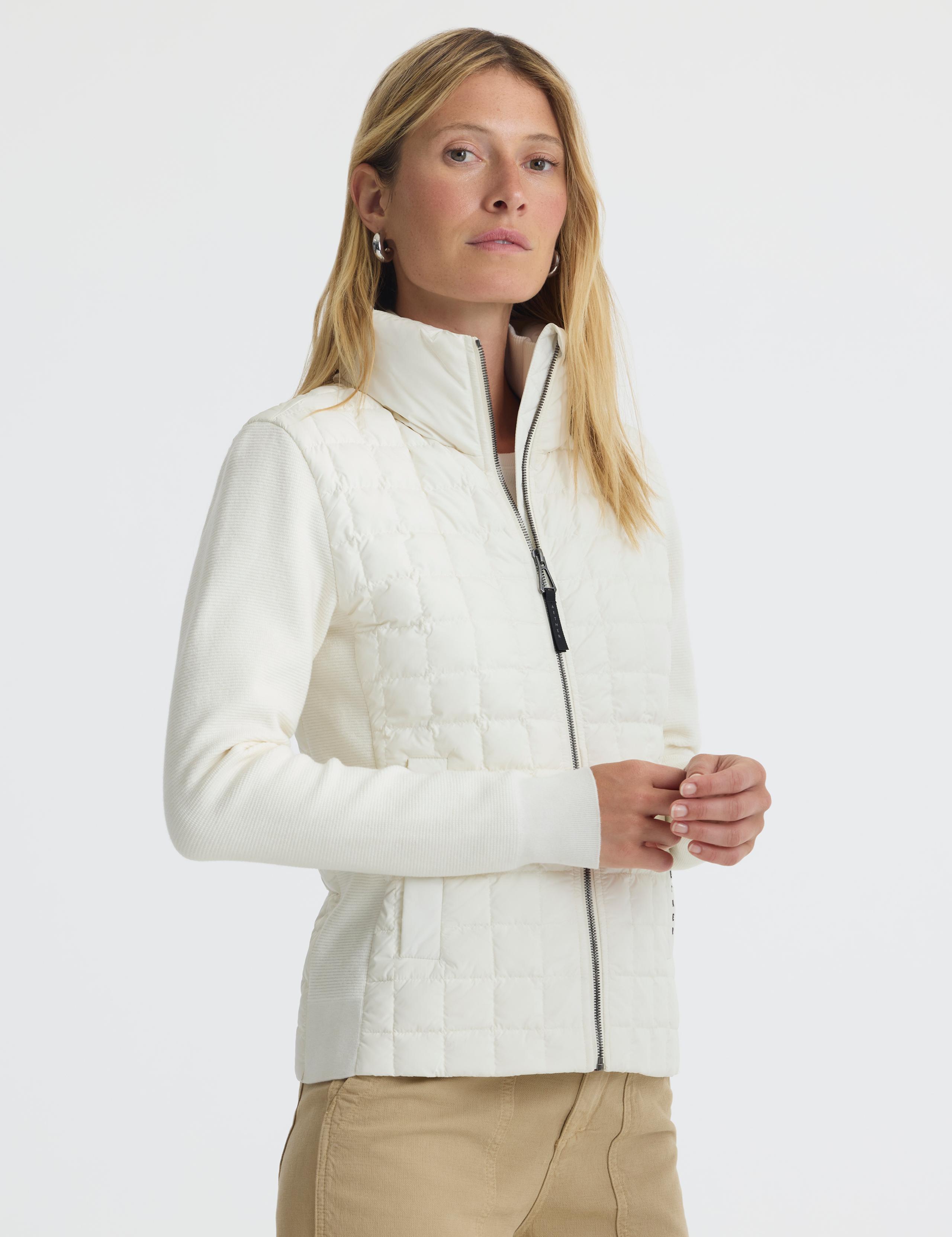Woman in studio wearing Phase Full-Zip in Winter White