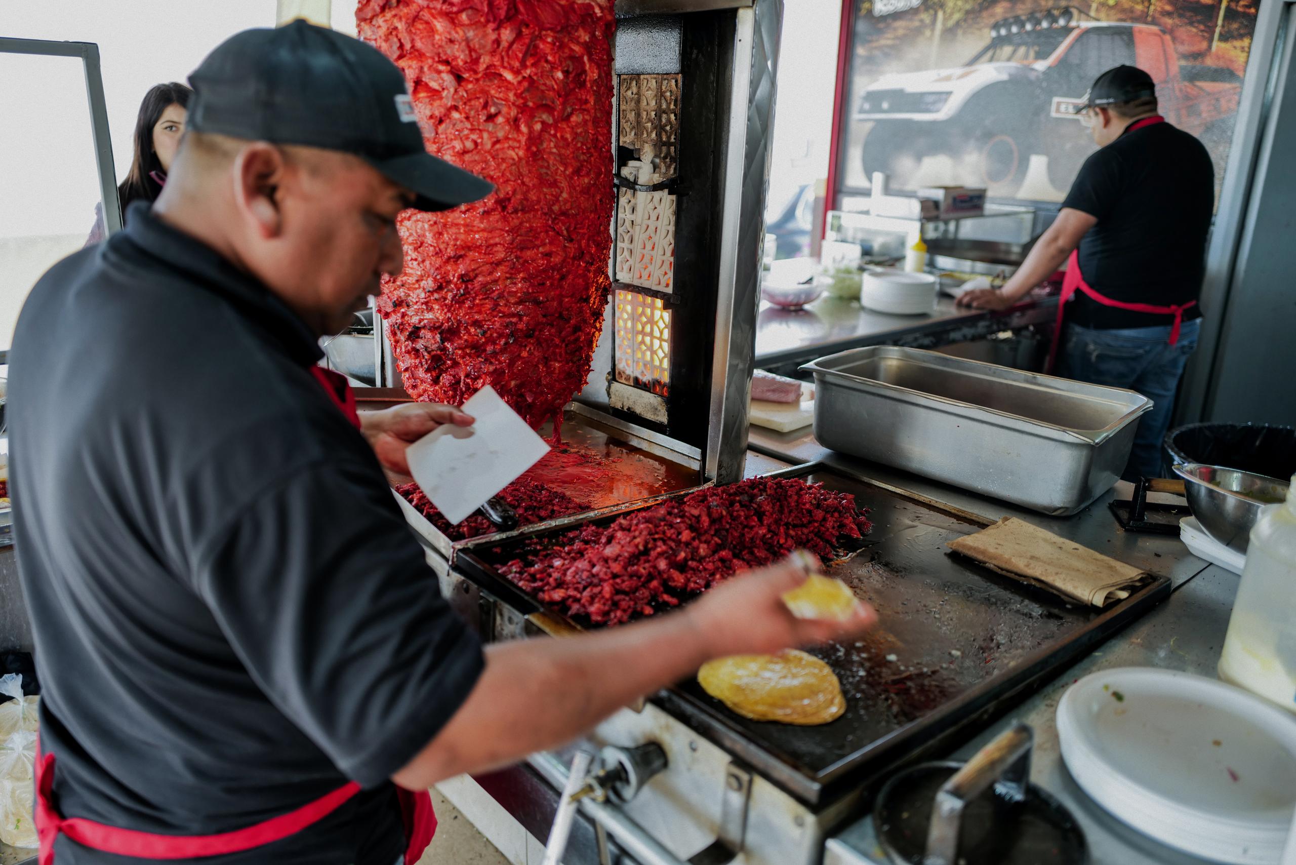 Man cooking meat on large hot plate in Ensenada, Baja California