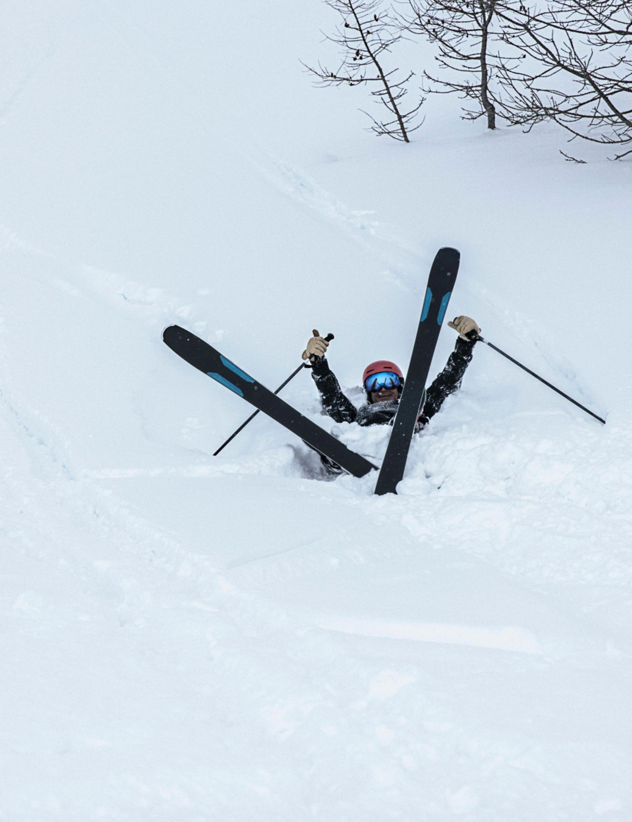 Skier fallen in deep snow smiling
