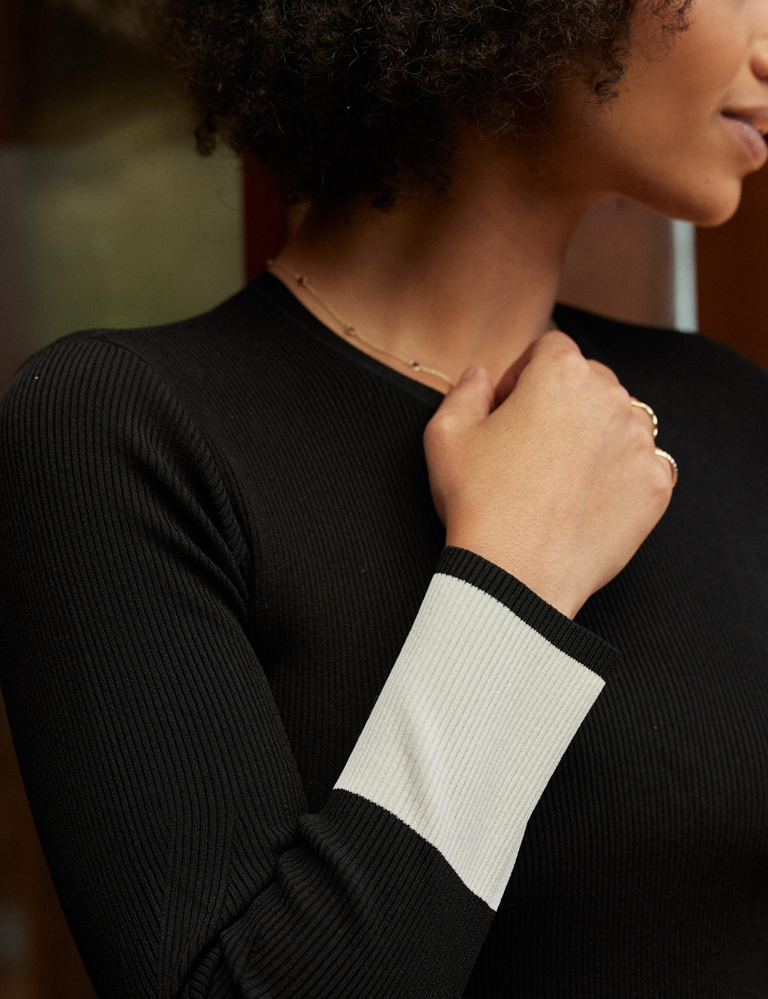 Woman wearing Rib-Knit Crew sweater holding arm to her chest
