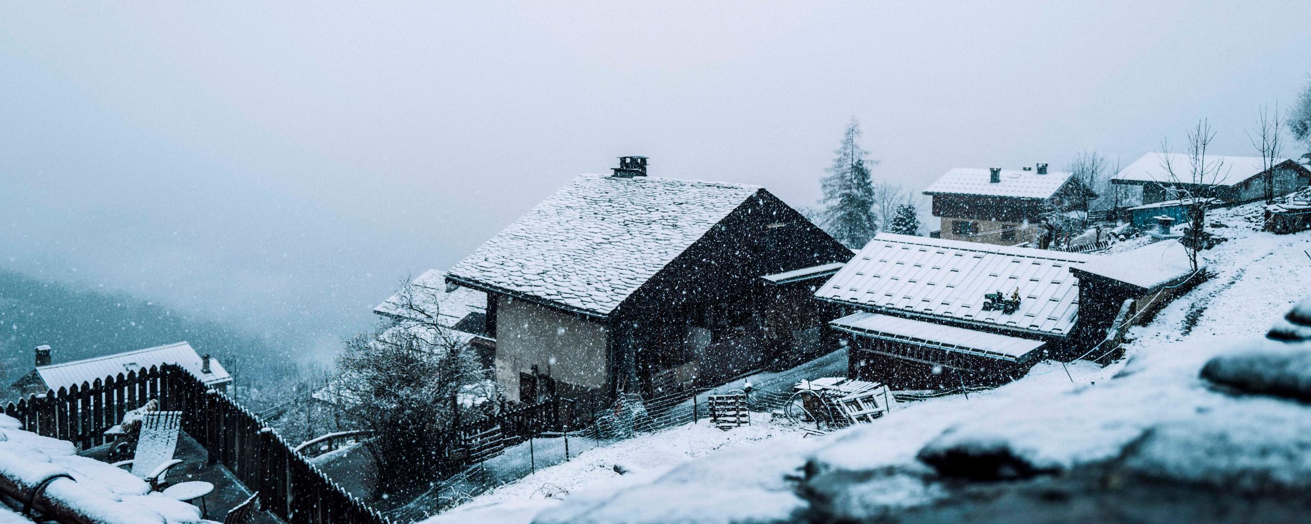 Snow falling on mountainside town in the French Alps