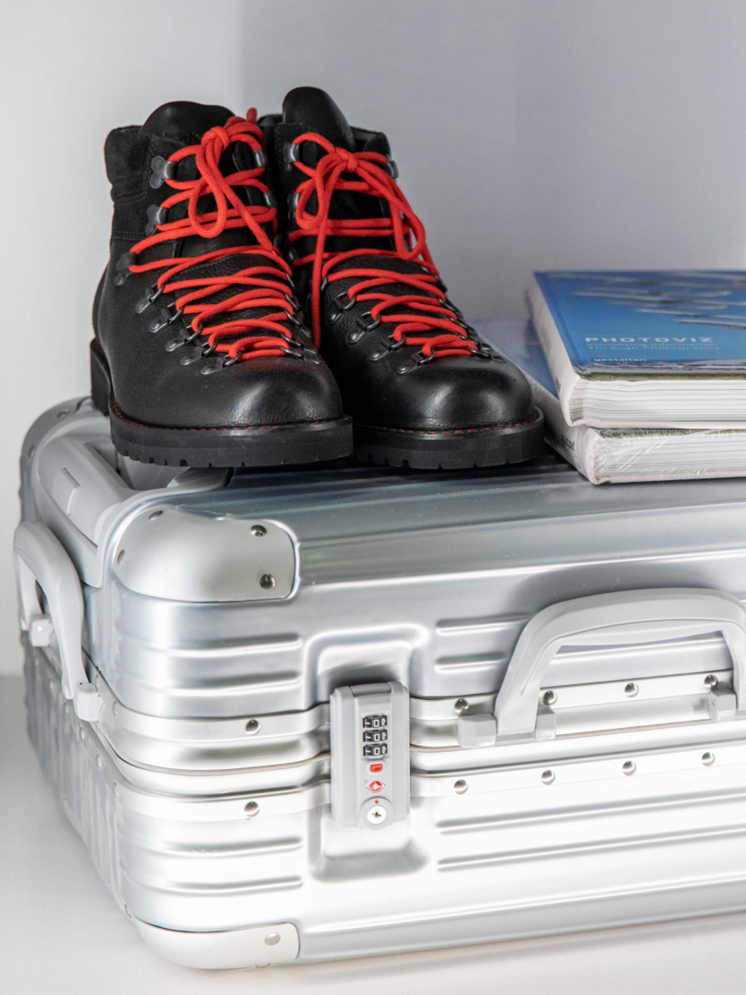 View of AETHER boots sitting top of aluminum luggage