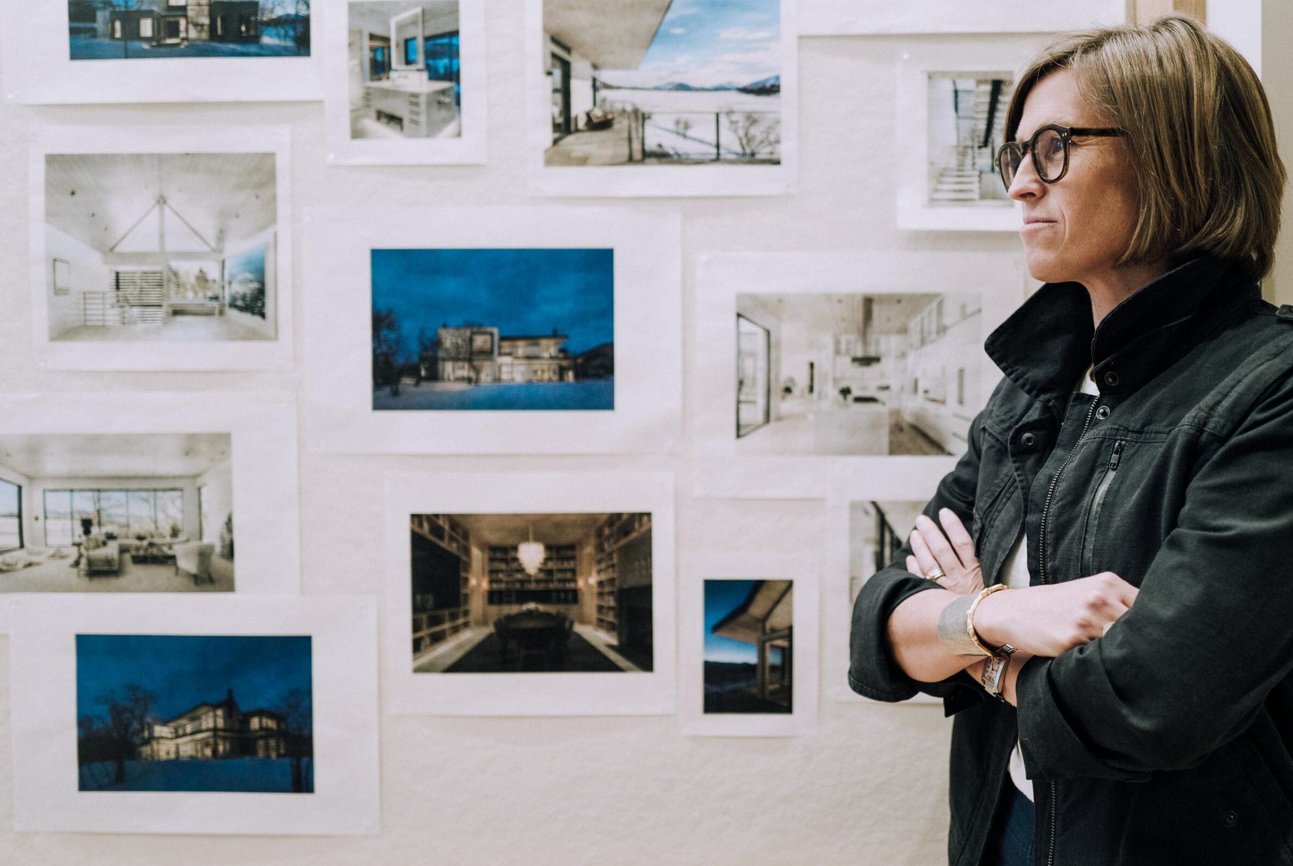 Sarah Broughton standing in front of wall with photographs