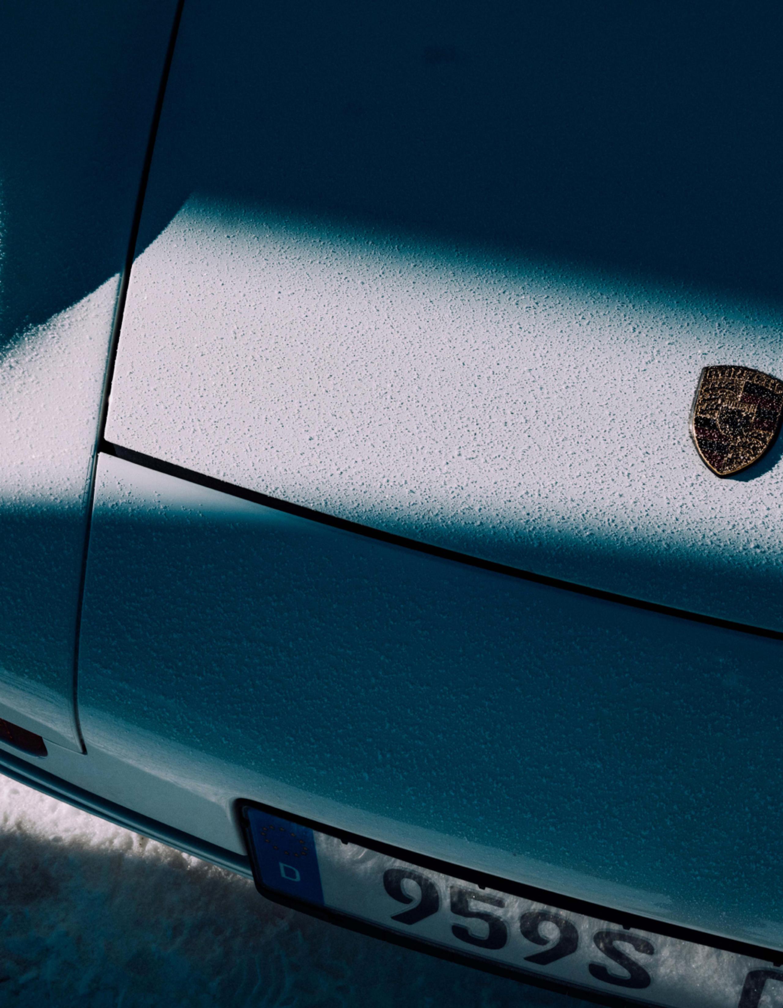 Closeup view of Porsche 911 hood with shadow and light snow on top