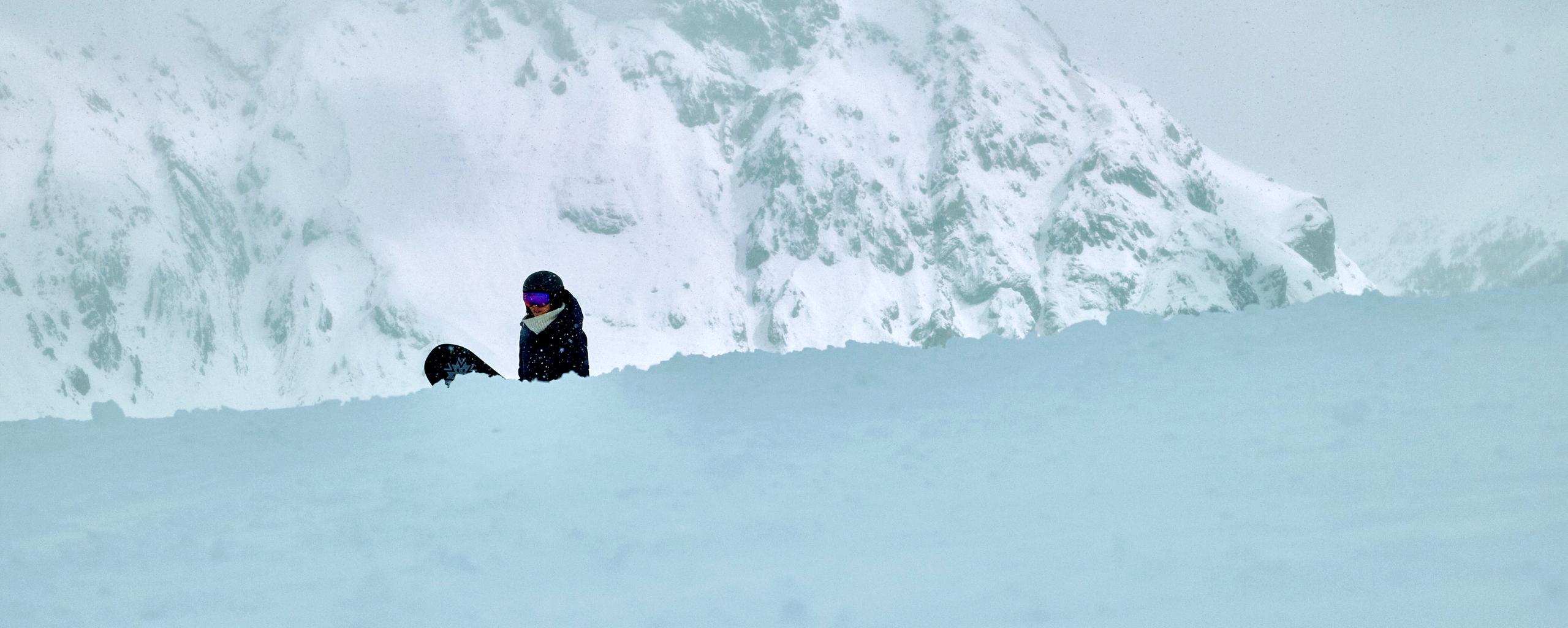 Woman walking with snowboard in French Alps