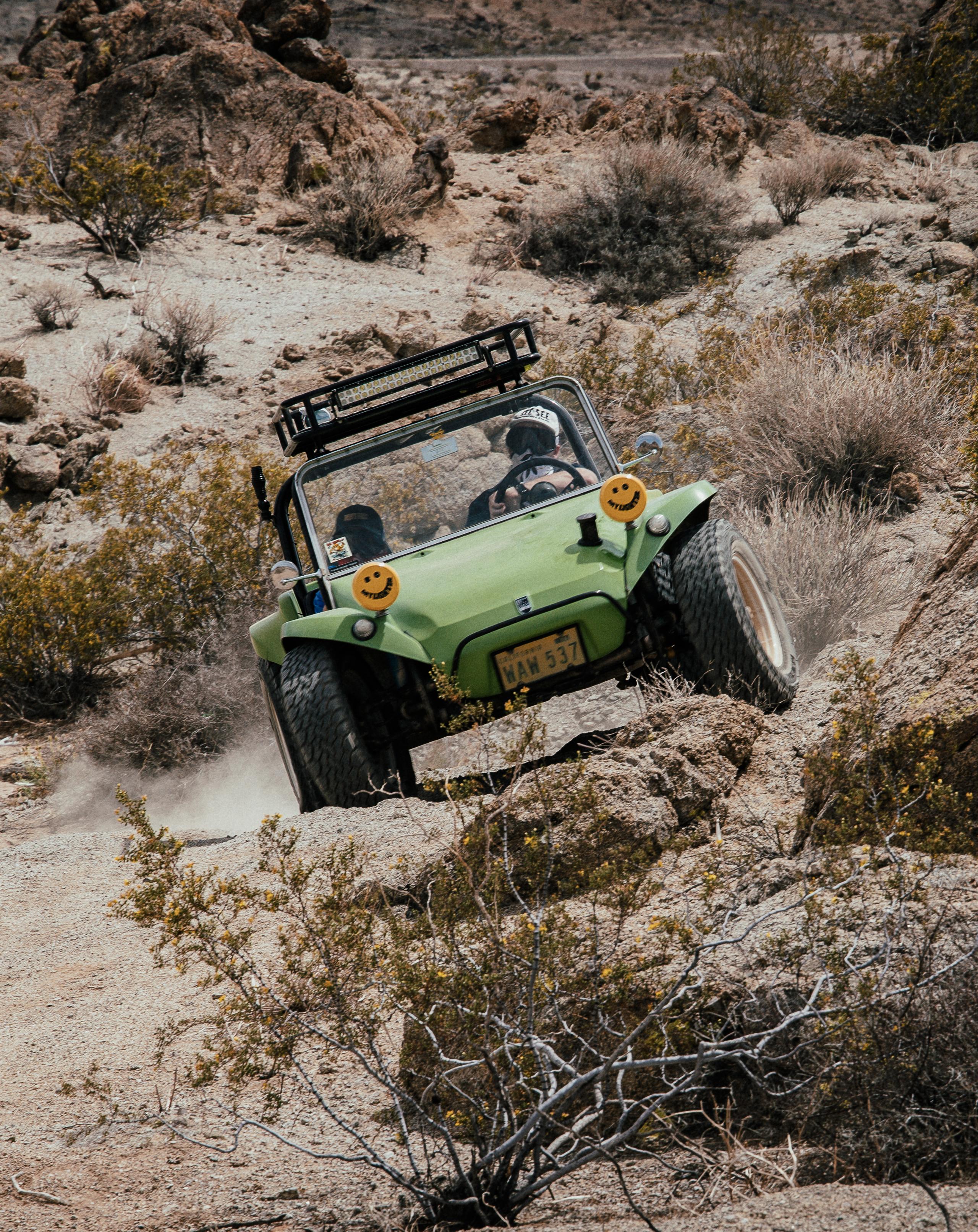 Modified green vehicle off-roading in the desert