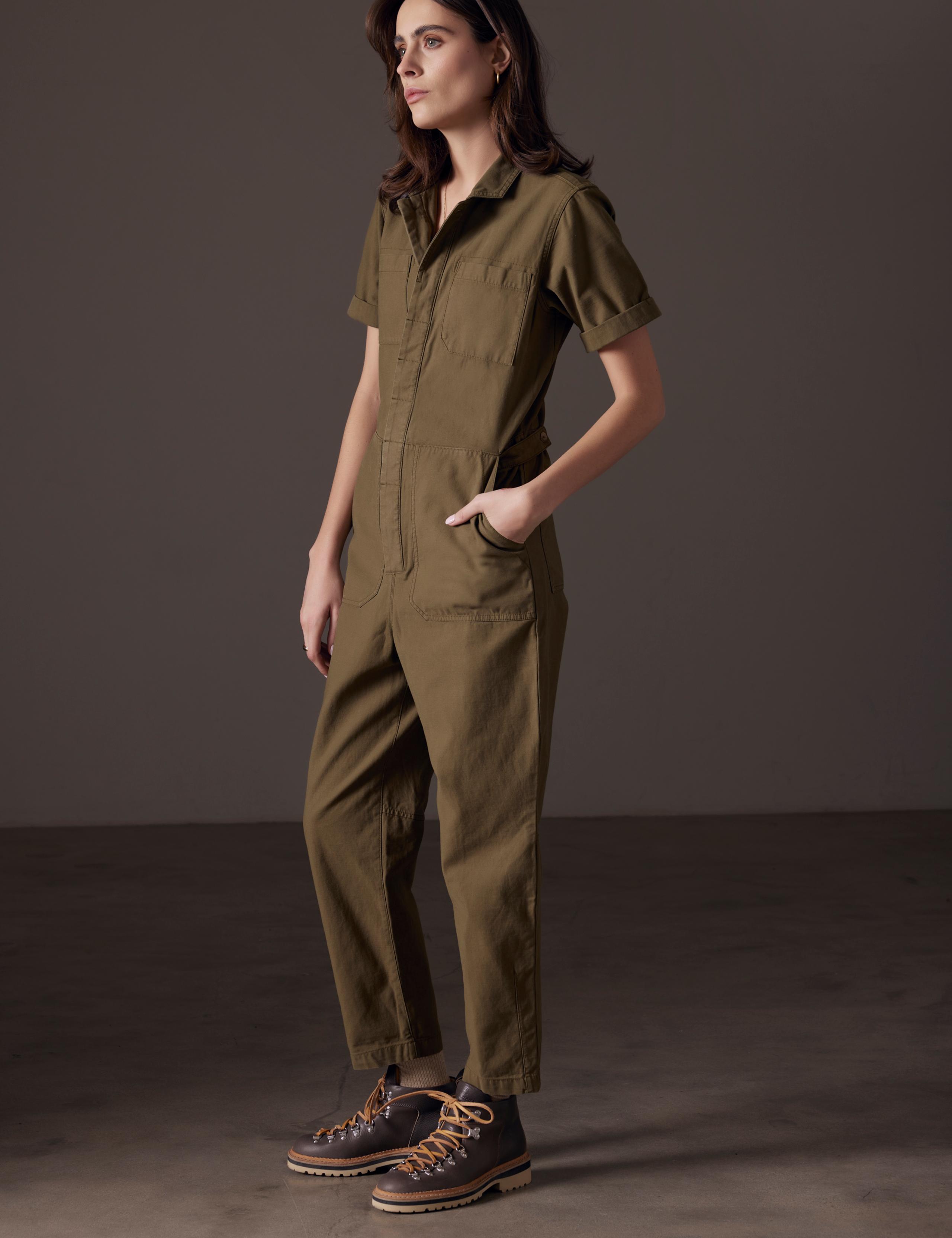 Woman in studio wearing the Bard Jumpsuit in Command Green