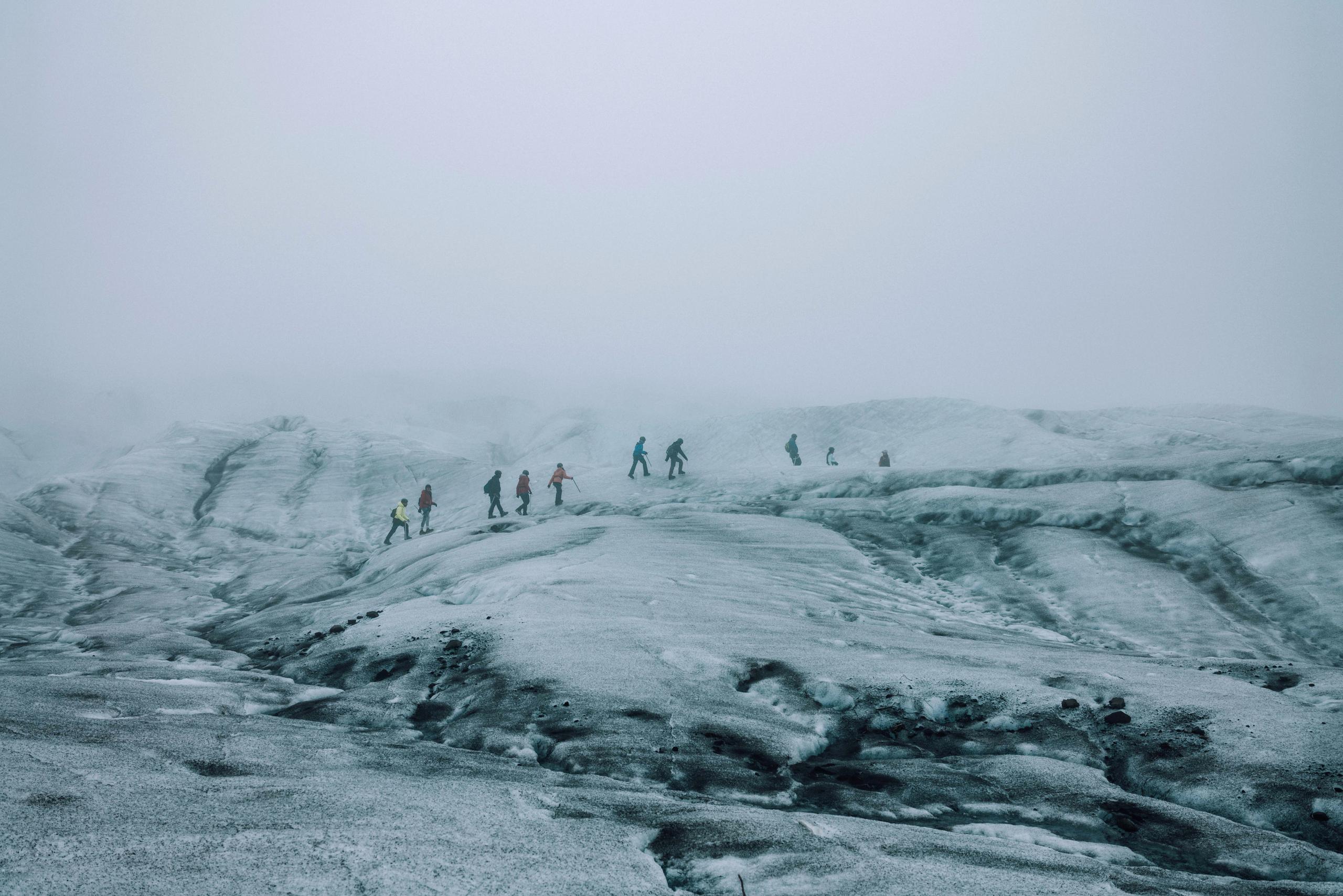 Landscape of 10 people crossing glacier in Iceland