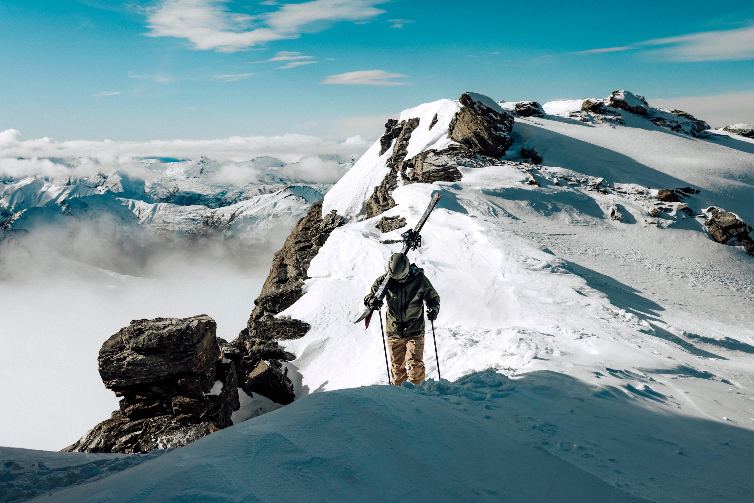 Skier hiking up mountain in New Zealand