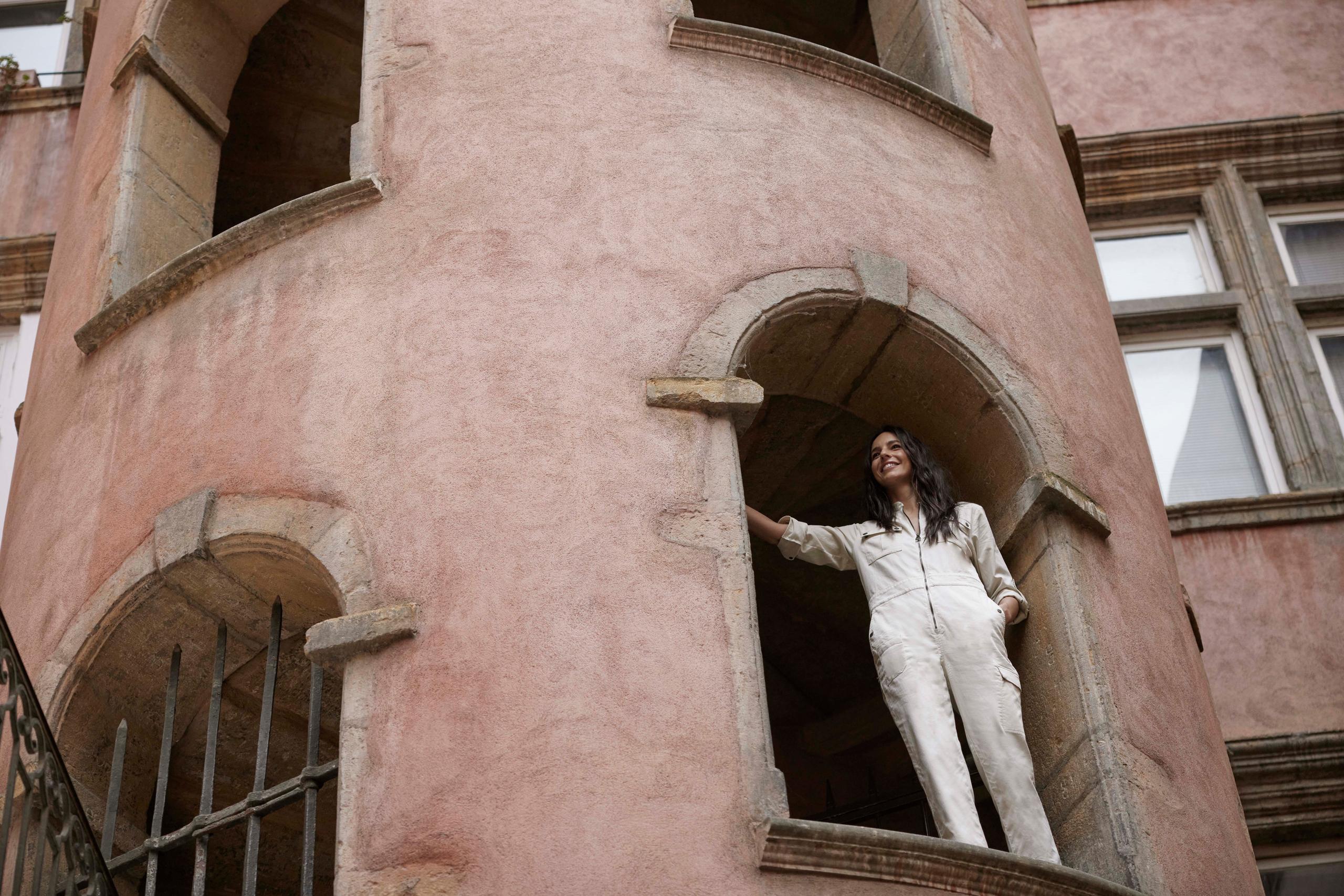 Woman wearing Luna Jumpsuit standing in window of an old building in Lyon, France