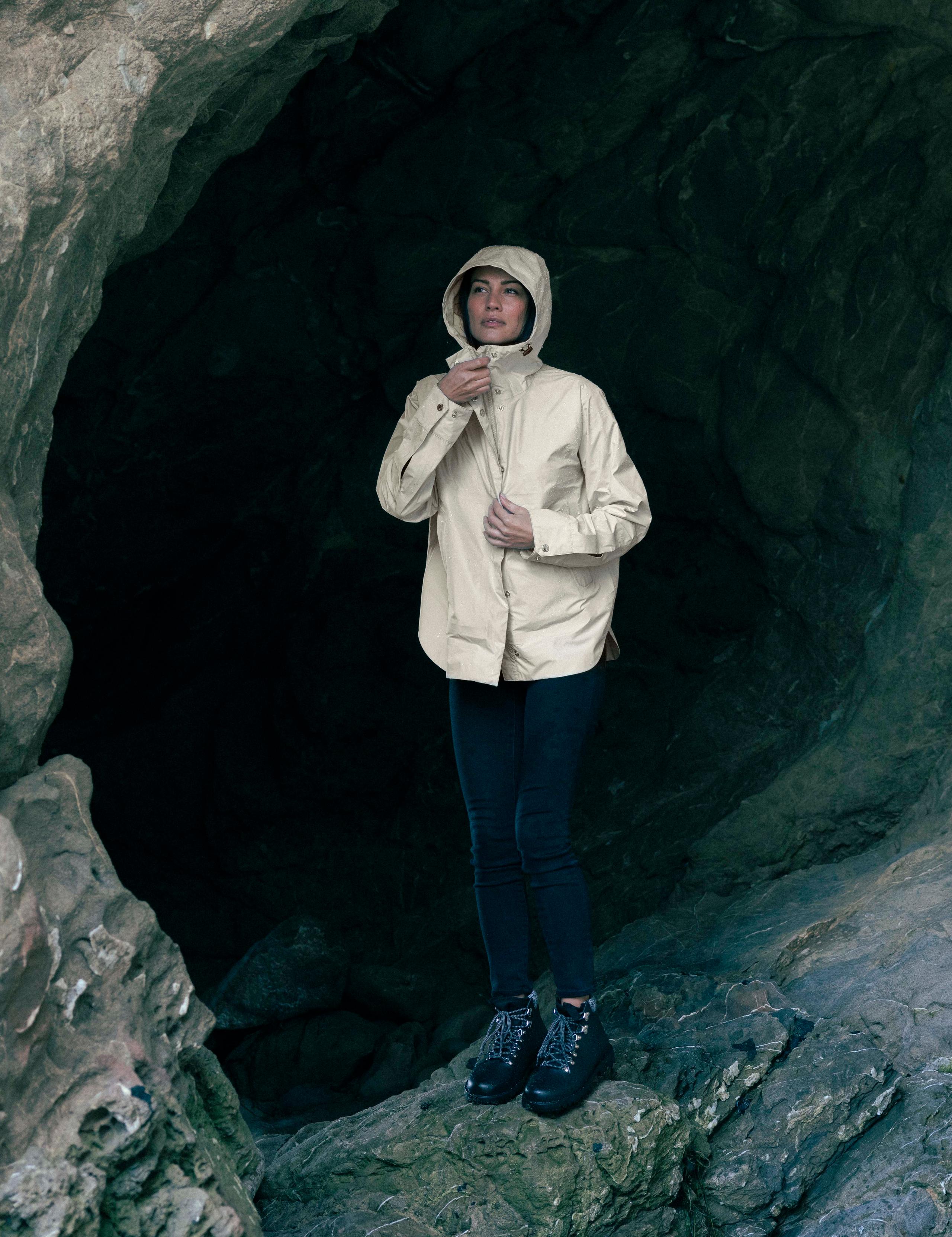 A woman wearing W Storm All-Weather Jacket in a cave