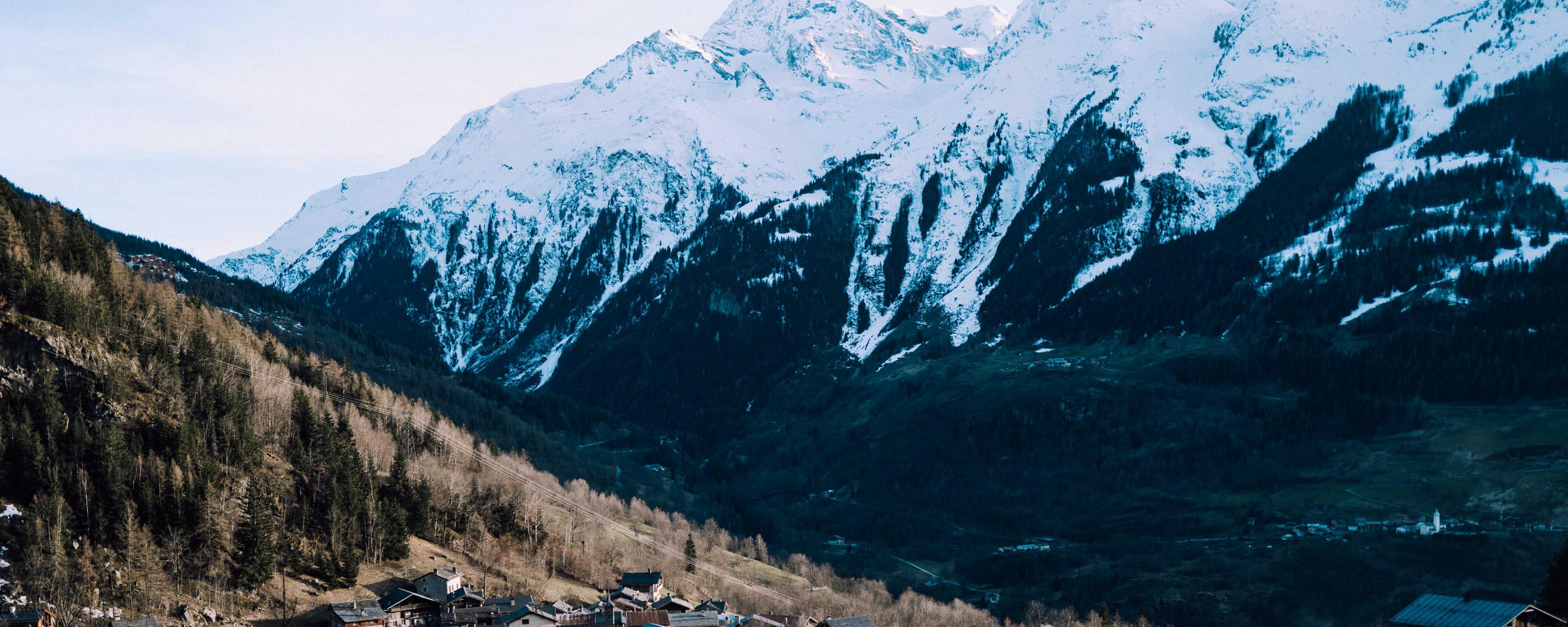 Landscape view of mountain town with snowy mountains in background