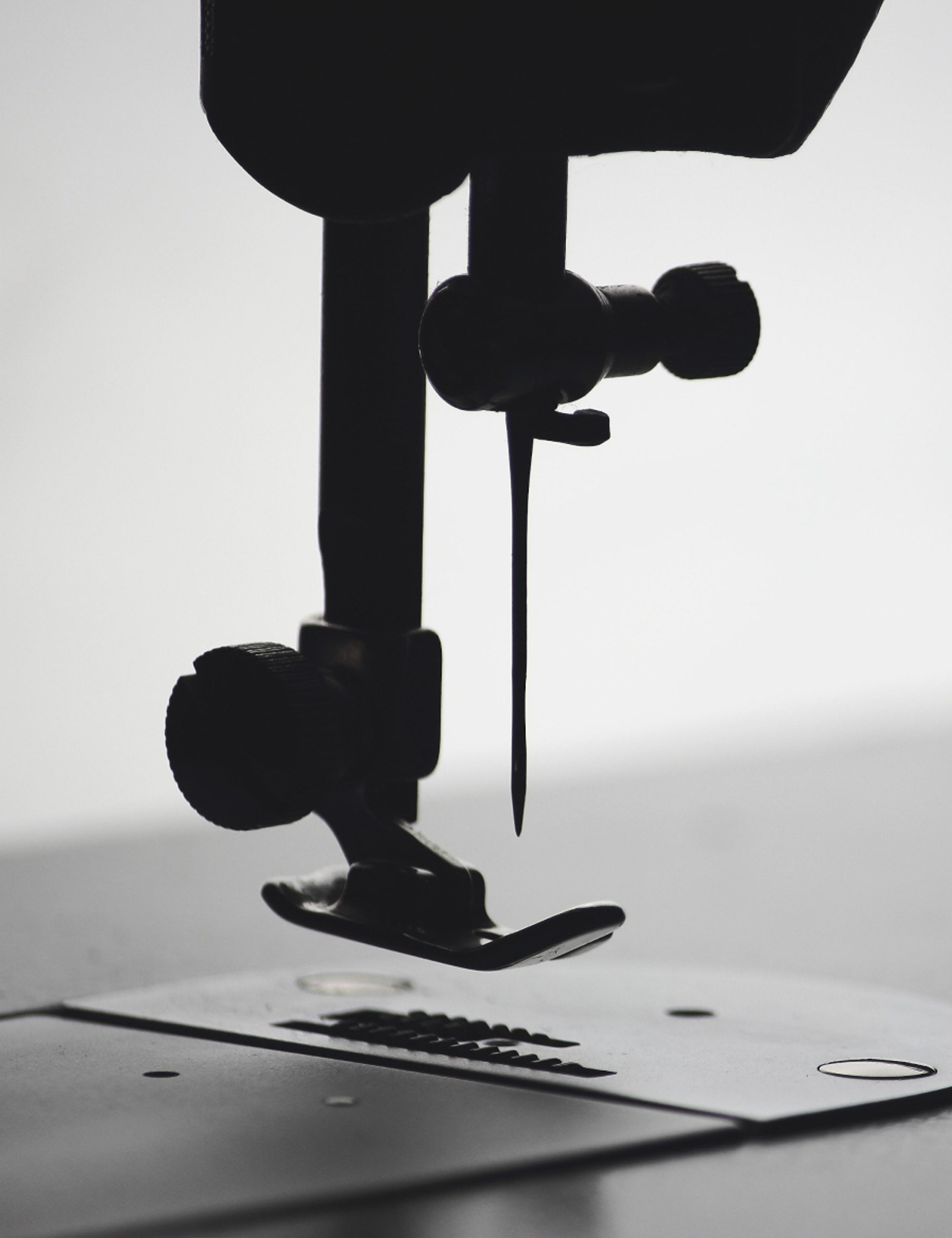 Black and white closeup of sewing machine needle