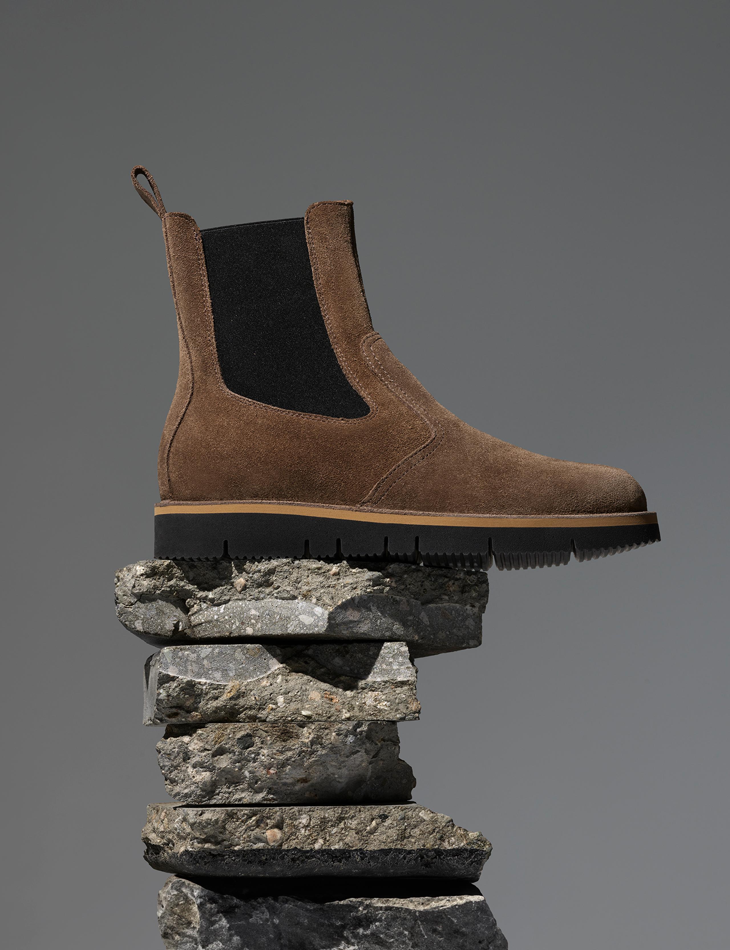 Studio photo of AETHER Chelsea Boot sitting on stack of rocks