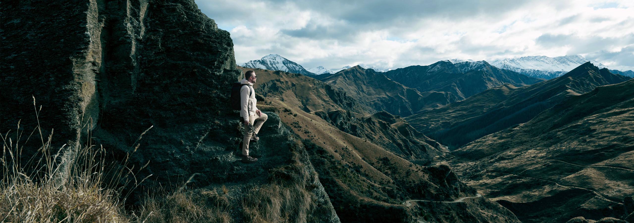 Woman stepping up to roof of white Defender truck in Iceland landscape