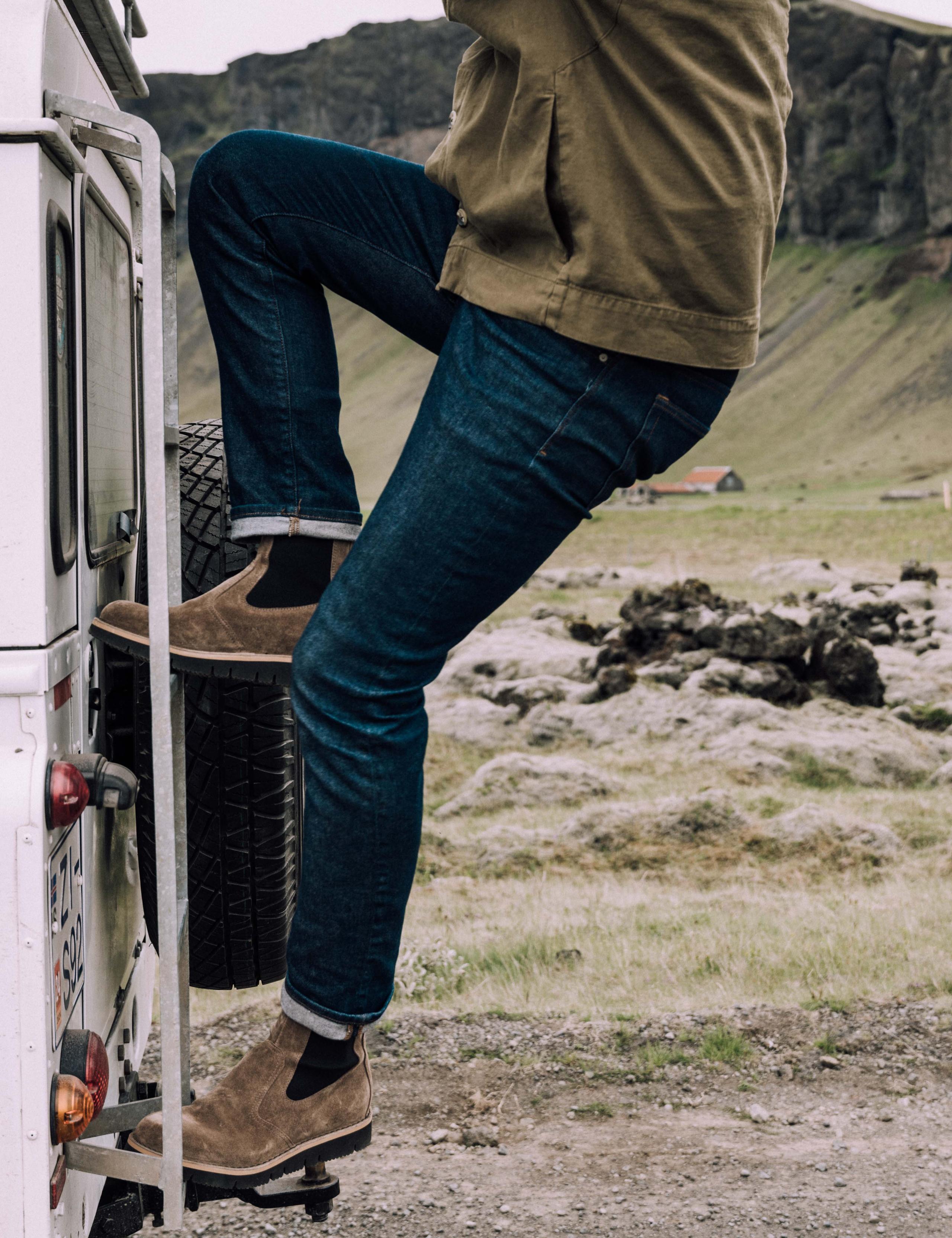 Men in AETHER Chelsea Boot climbing up on an SUV