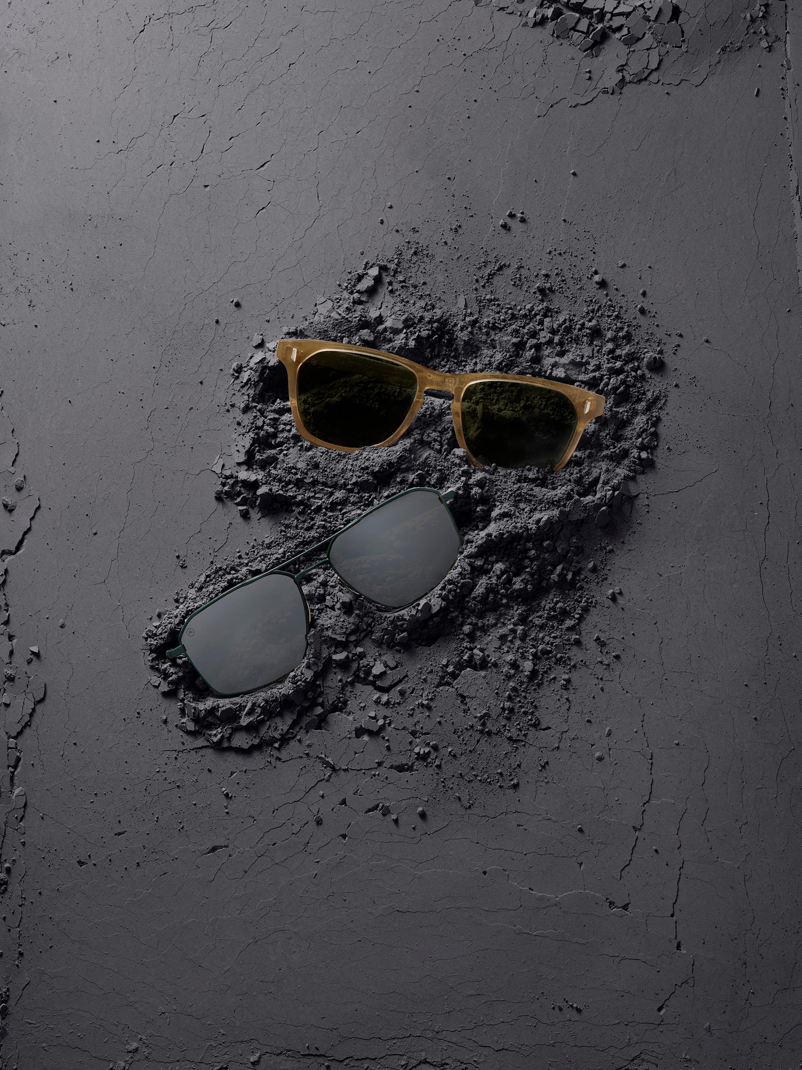 Studio photo of Yosemite and Bryce sunglasses in dark cement material next to photo of woman closing vehicle hatch in desert dunes