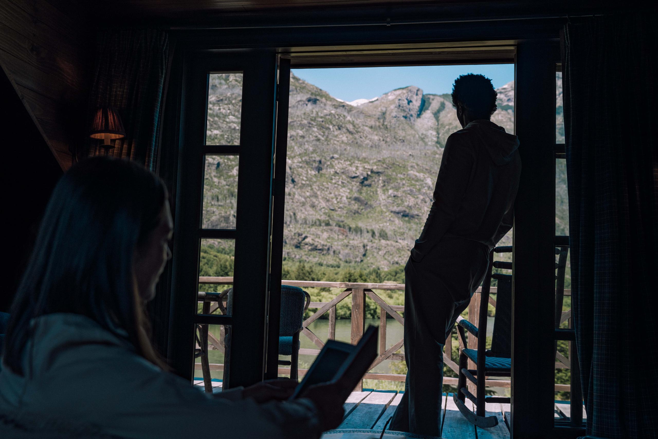 Silhouette of man and woman in lodge overlooking Patagonia mountains