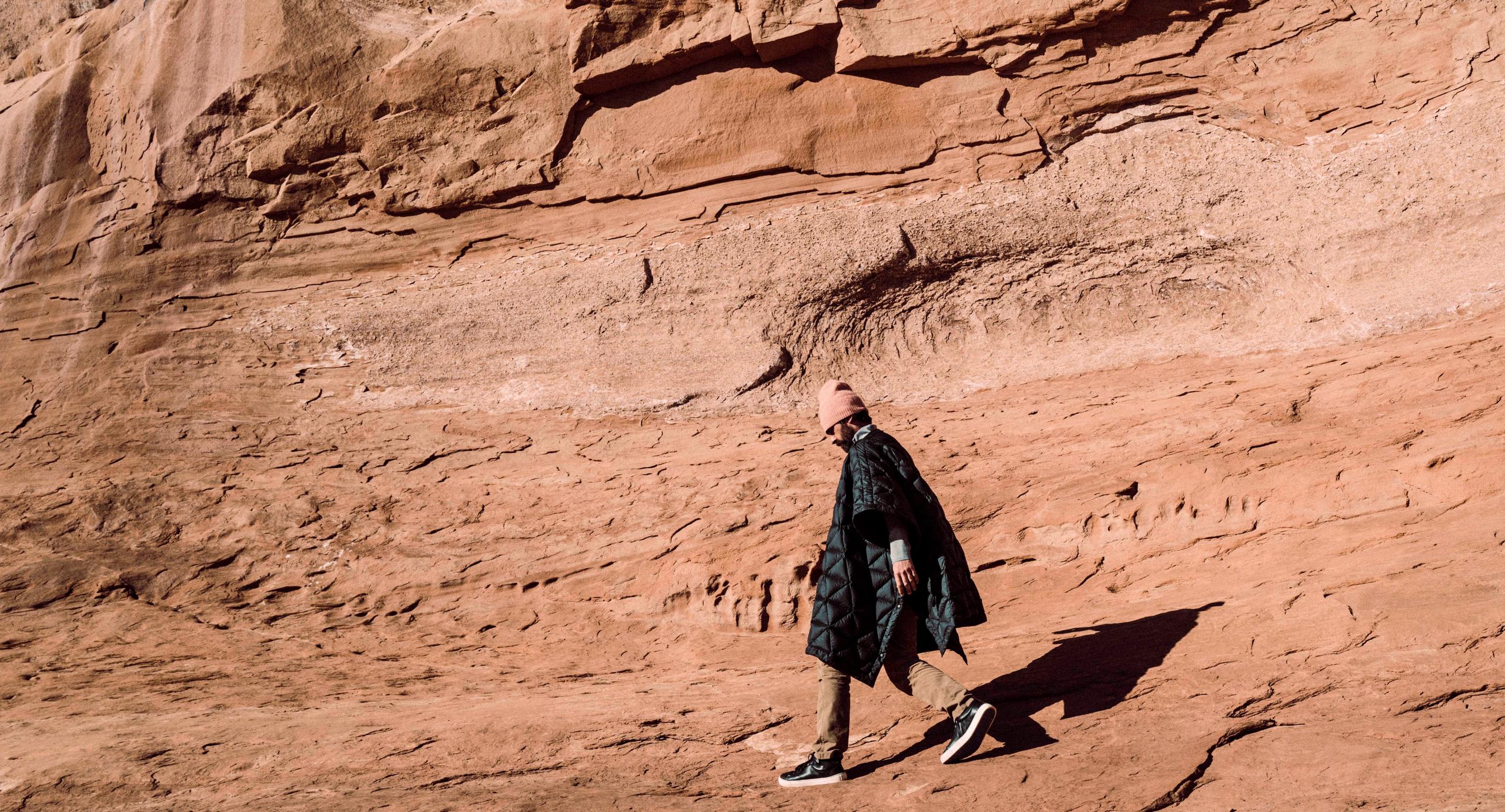 Man walking against mountain wall in Moab, Utah